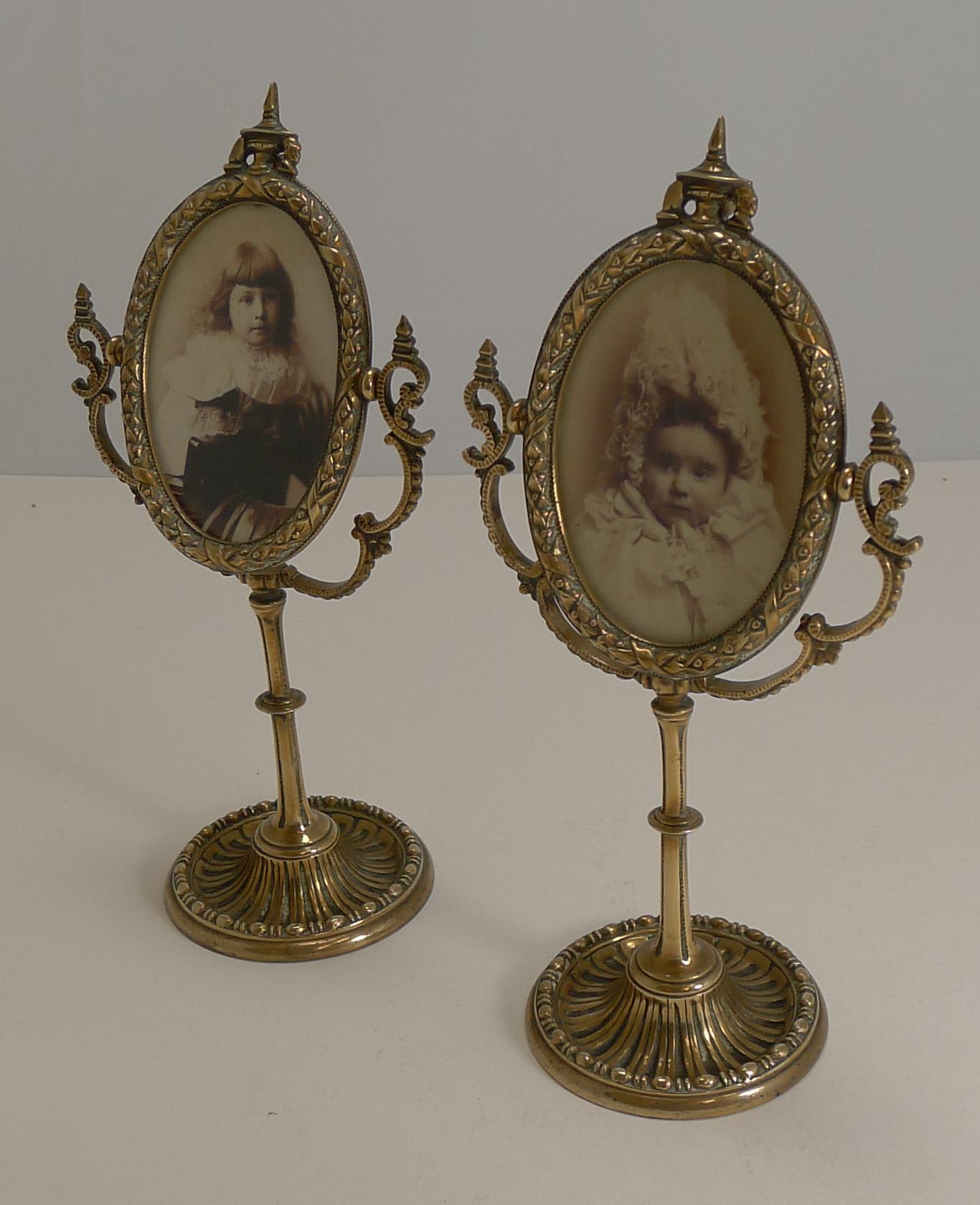 A most unusual and highly decorative pair of English Victorian photograph frames made from solid cast brass. The frames themselves are adjustable within the outer stand.

The bars at the back are unscrewed to allow the backs to be removed to