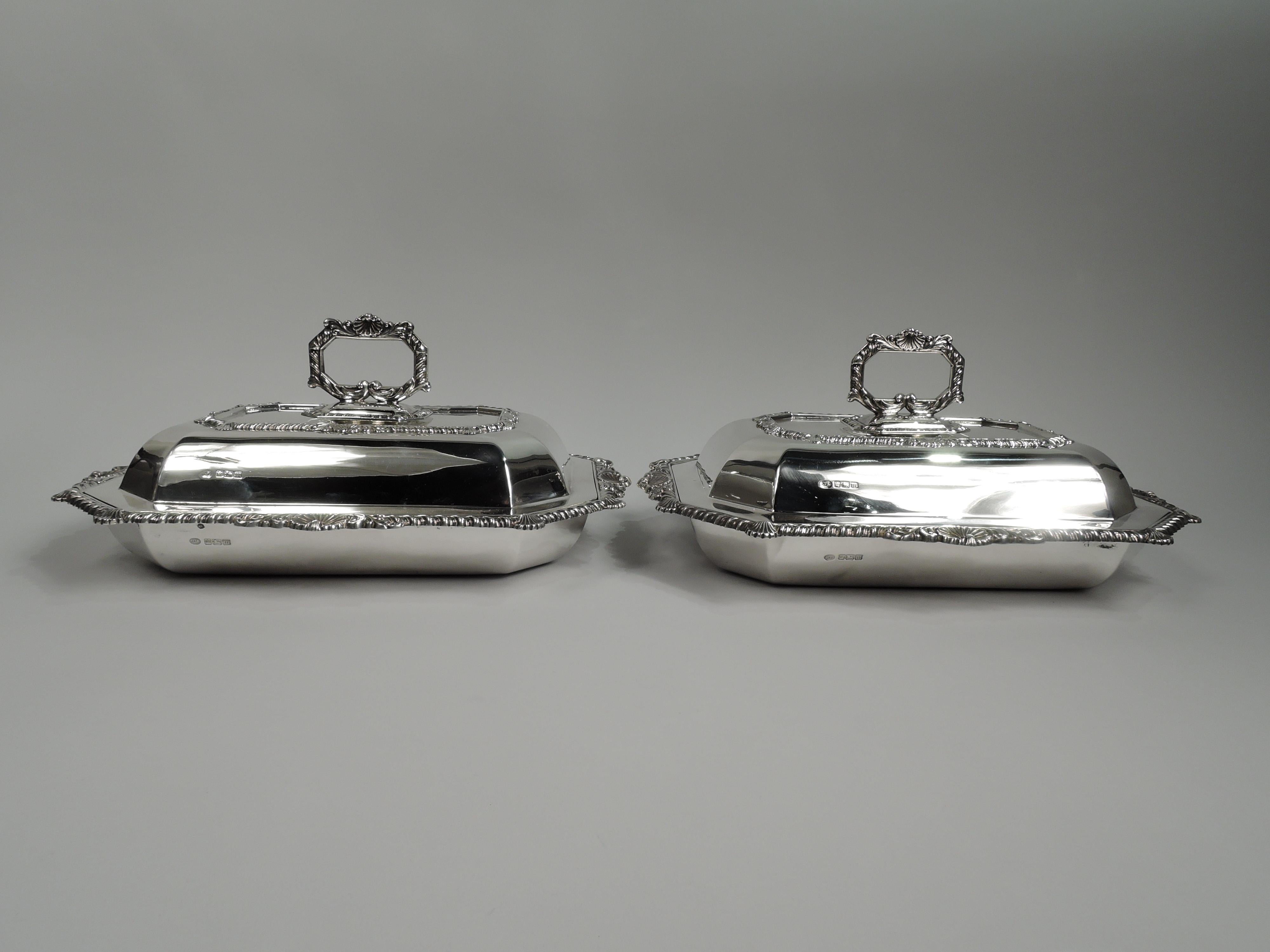 Pair of Edwardian Georgian sterling silver covered serving dishes. Made by John Round & Son Ltd in Sheffield in 1904. Each: Rectangular with chamfered corners and tapering sides. Cover raised and chamfered with twist-lock ring handle. Handle,