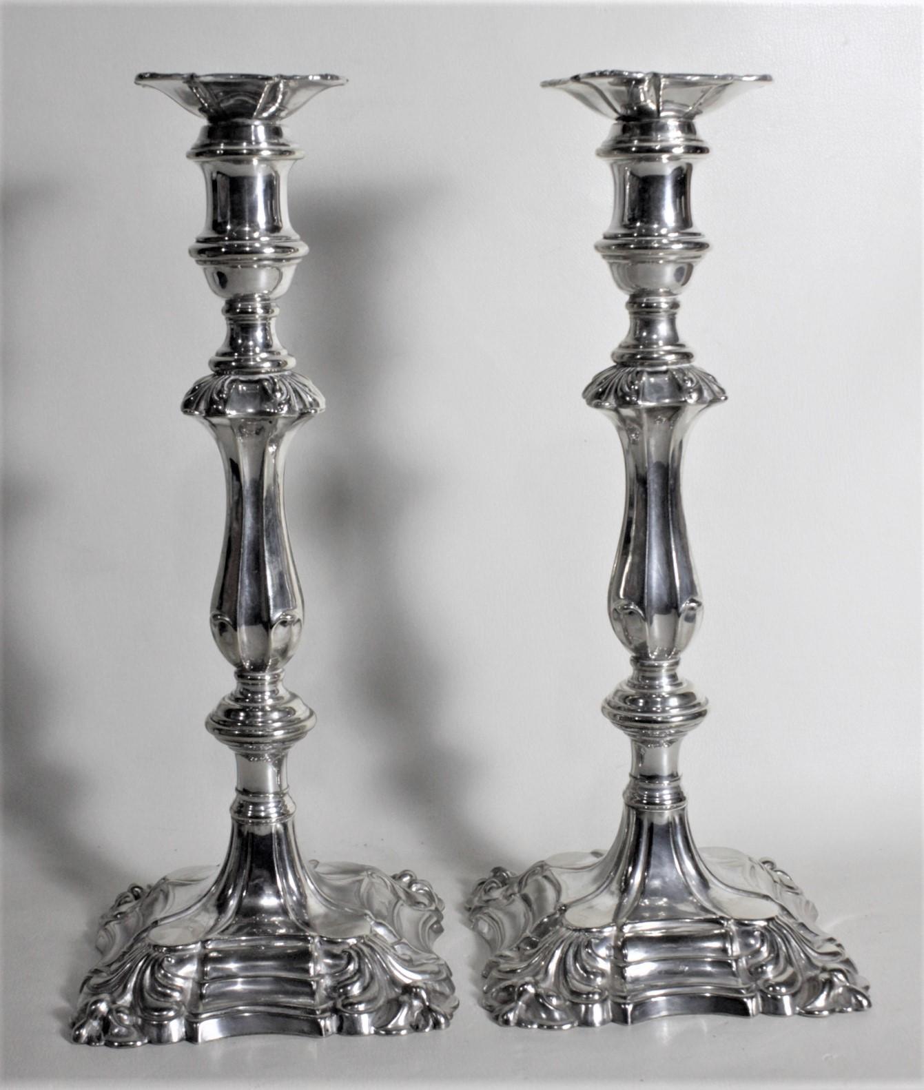 Cette paire de chandeliers anciens en métal argenté porte le poinçon 