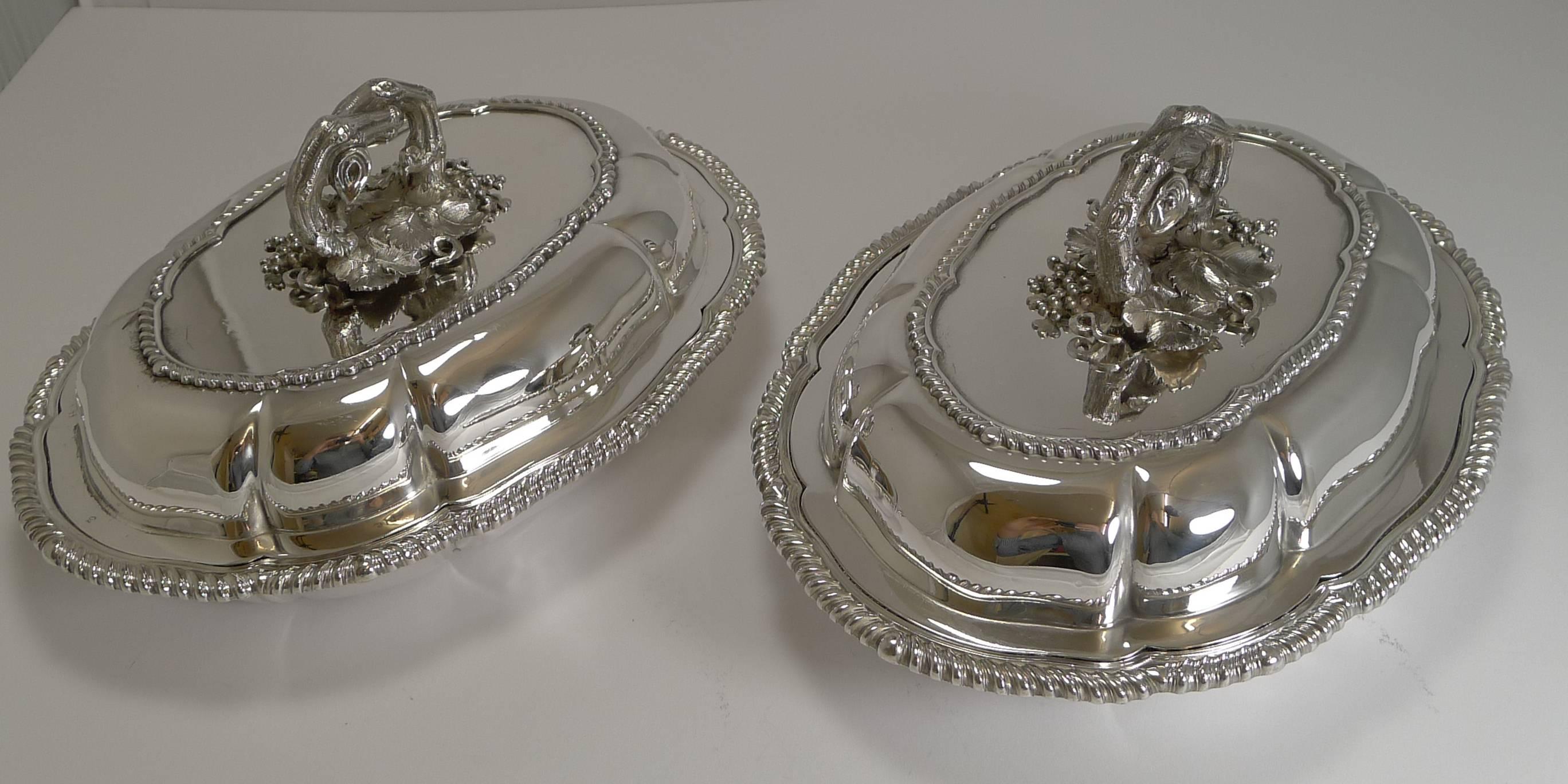 A fabulous pair of Victorian silver plated Entree dishes with an elegant shape and crowned exquisite naturalistic handles.

Made by the most important manufacturers of English silver plate, Elkington and Company. Being Elkington, it allows us to