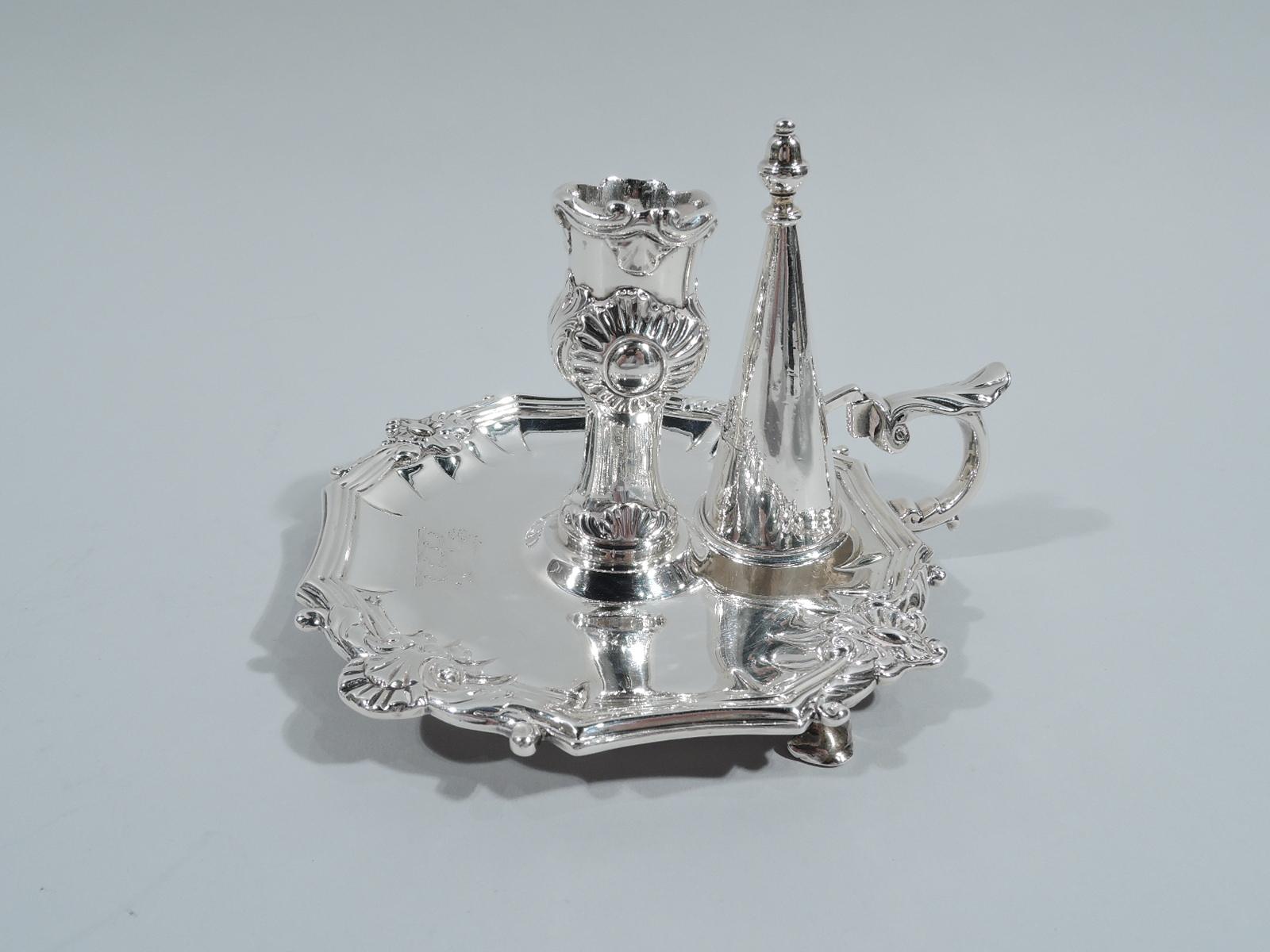 Pair of George III sterling silver chambersticks. Made by William Burwash in London in 1818. Each: Bellied socket on upward tapering faceted support mounted to round shaped stand on hoof supports. Conical snuffer with vasiform finial set in