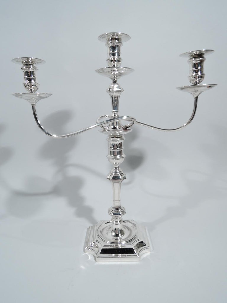 Pair of George V sterling silver 3-light candelabra. Made by Lionel Alfred Crichton in London in 1933. Each: Spool socket, chamfered and knopped pillar shaft, and square foot with chamfered corners. Raised central spool socket with reeded wraparound