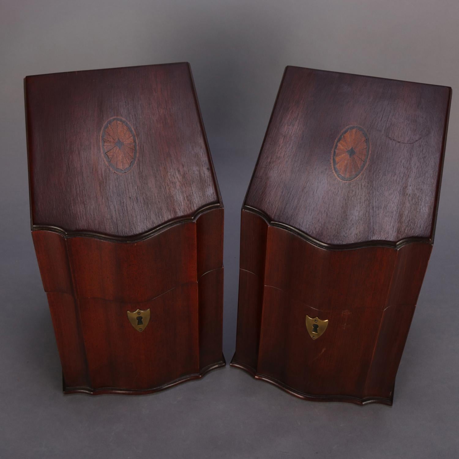 A pair of English Georgian knife boxes feature serpentine form with lid having satinwood inlaid patera and opening to interior with 12 knife slots, each with shield form bronze decorative escutcheon, 20th century

Measures: overall 13.25