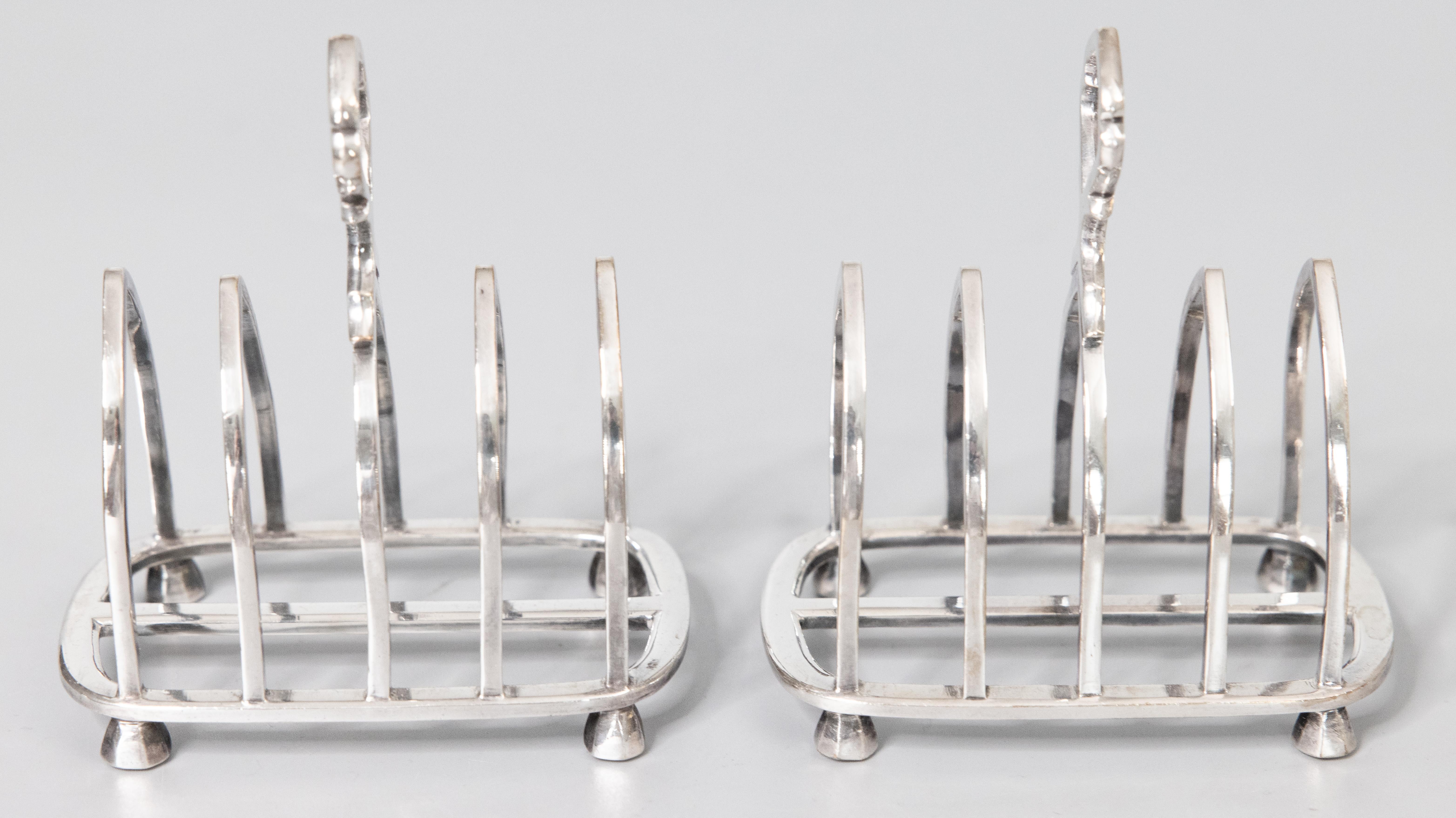 A superb pair of antique English silverplated toast racks, dated 1923. Maker's mark and hallmarks on reverse. These fine quality silver toast racks are well made with a lovely Gothic shape, decorative finial, and charming feet. They would be