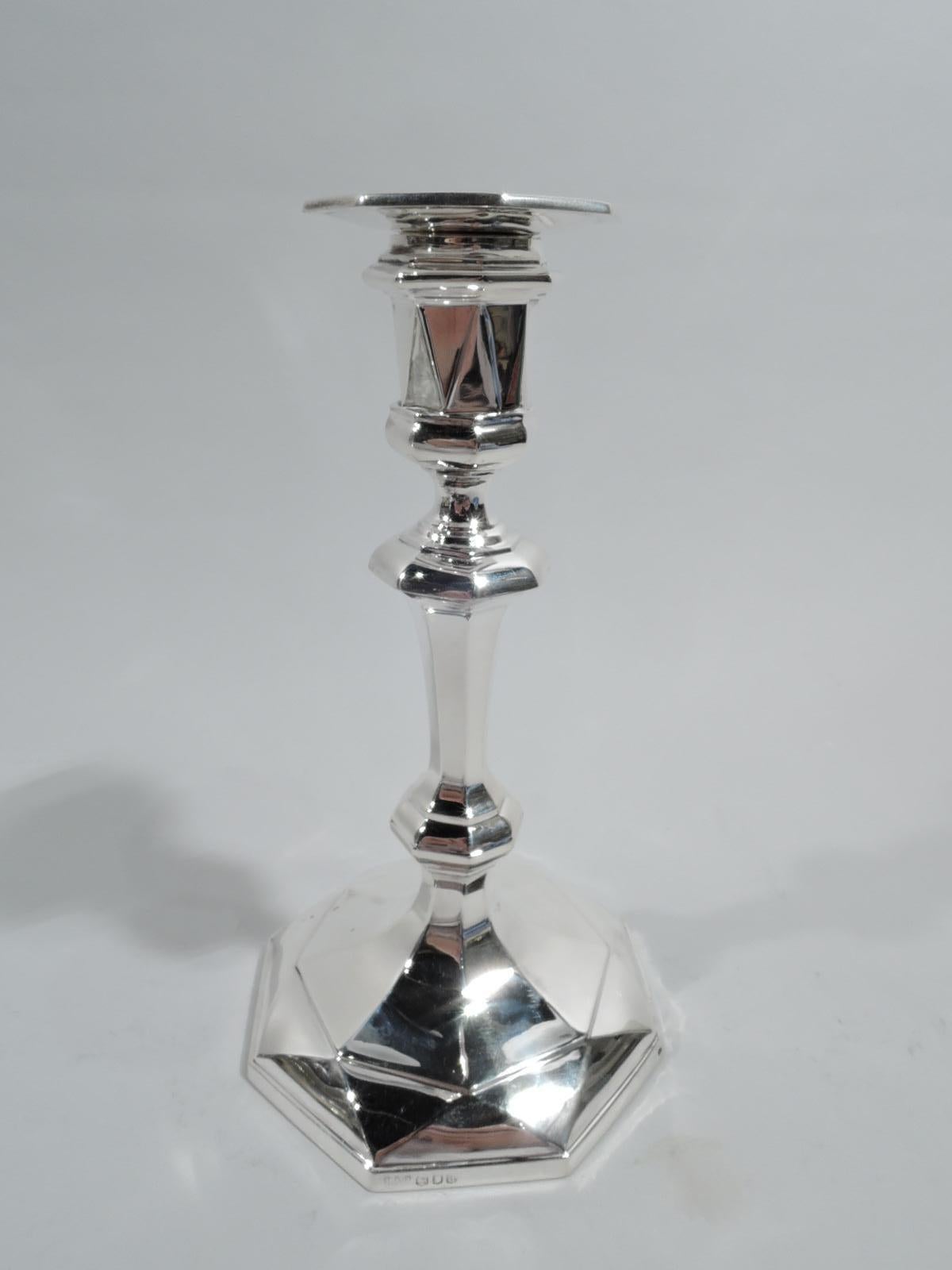 Pair of George V sterling silver candlesticks. Made by Lionel Alfred Crichton on London in 1916. Each: Tapering and knopped shaft on raised foot; bellied socket with detachable bobeche. Traditional Georgian form revved up with facets and triangles.