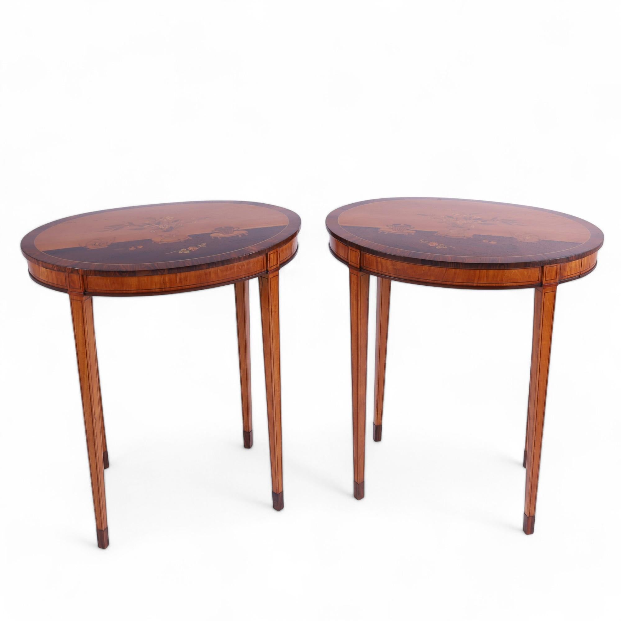 Charming pair of Edwardian, Adams style English stands crafted in mahogany, rosewood and satinwood with oval tops having inlaid chinoiserie flowers, pots and vases in exotic woods, on tapered legs with string inlaid outlines on rosewood feet. 