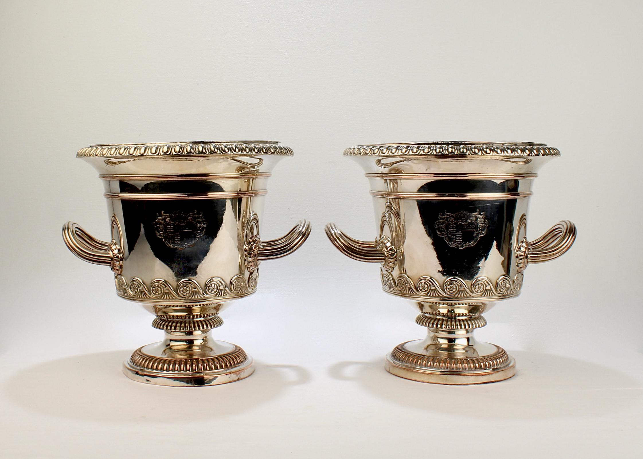 A very fine pair of antique English Sheffield Plate wine coolers.

From the Regency period.

Each with an armorial crest to one side, a rampant lion to the other, a gadrooned rim, reeded handles that terminate in florets, and a reeded foot and