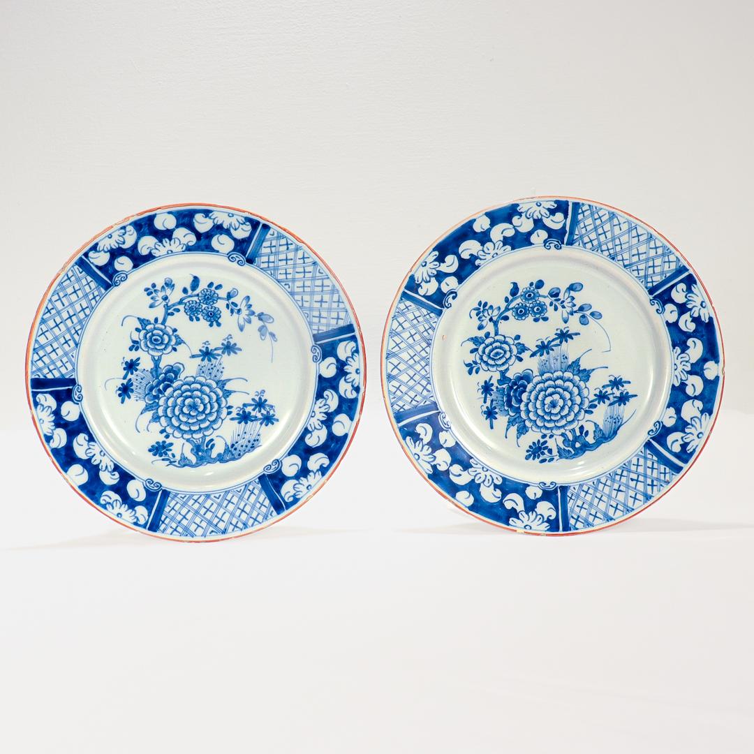 A fine pair of antique 18th century English or Irish Delft pottery plates.

With Chinoiserie decoration in blue underglaze decoration throughout including a stylized Chrysanthemum and a blossoming tree.

Both with labels to the bottom that read