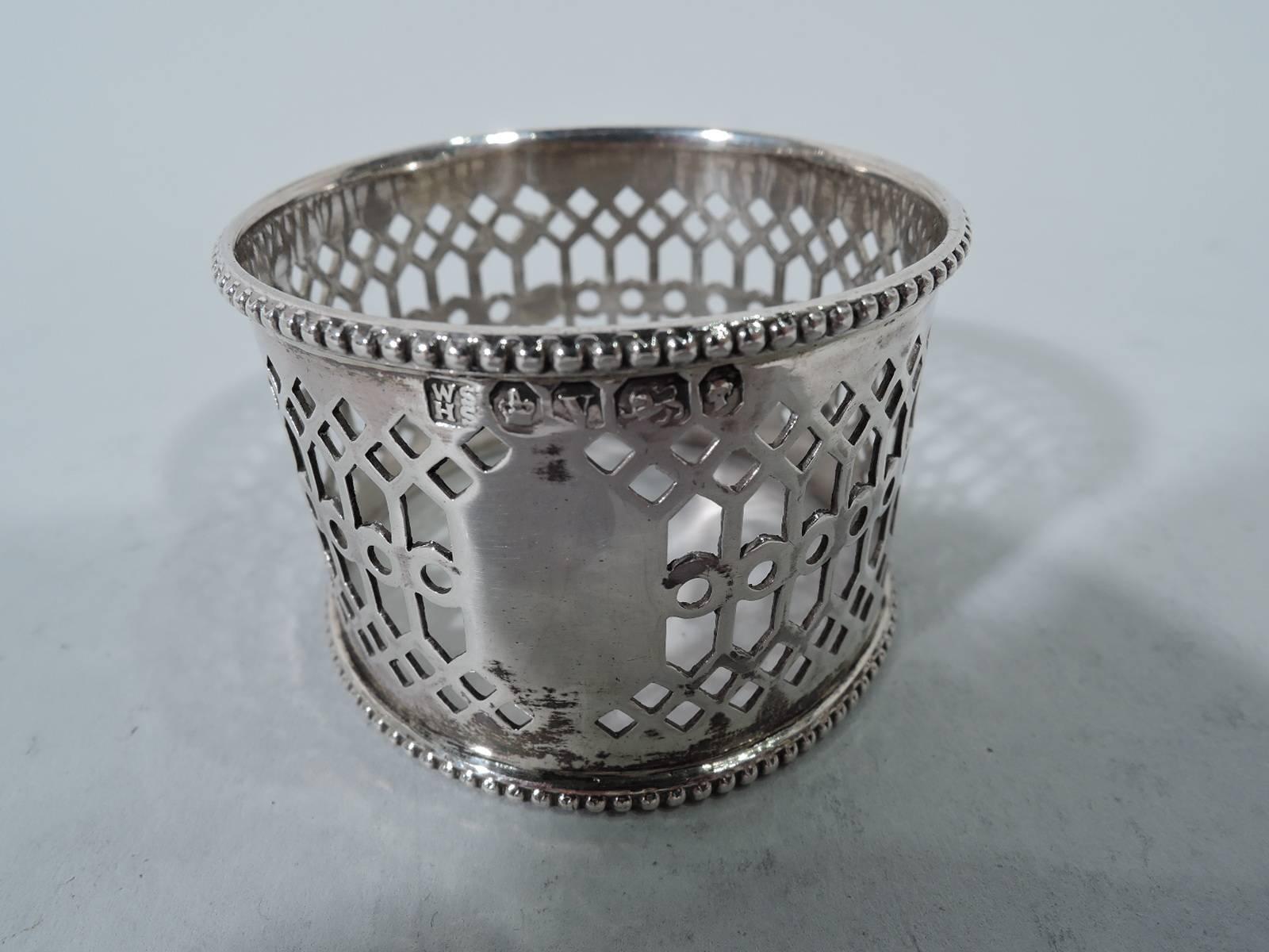 Pair of Victorian sterling silver napkin rings. Made by William & Henry Stratford in 1863. Each: Pierced tracery with solid frame (vacant). Beaded rims. In leather-bound case with fitted velvet and silk lining with retailer’s gilt stamp. Hallmarked.