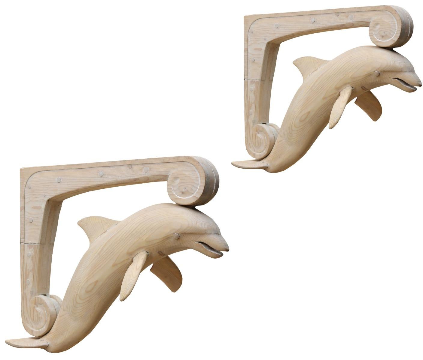 A stunning pair of dolphins carved in pine on a scroll bracket. These were originally porch supports, but could be put to many other decorative uses.