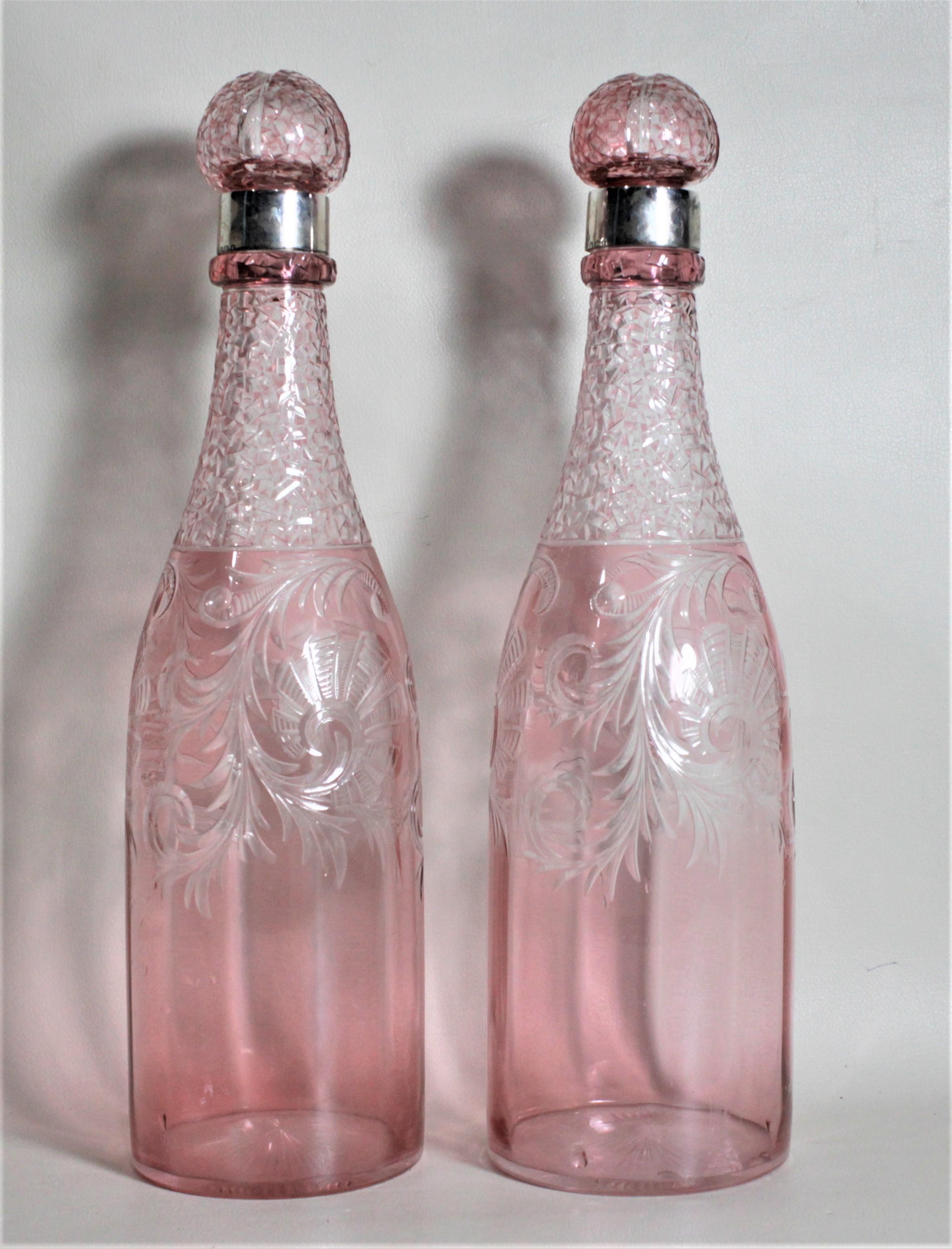This pair of Victorian cut cranberry crystal bottle decanters were made in Sheffield England in circa 1895. These matching pink decanters have been ornately hand cut with swirled floral decoration on both sides and are done with a textured finish