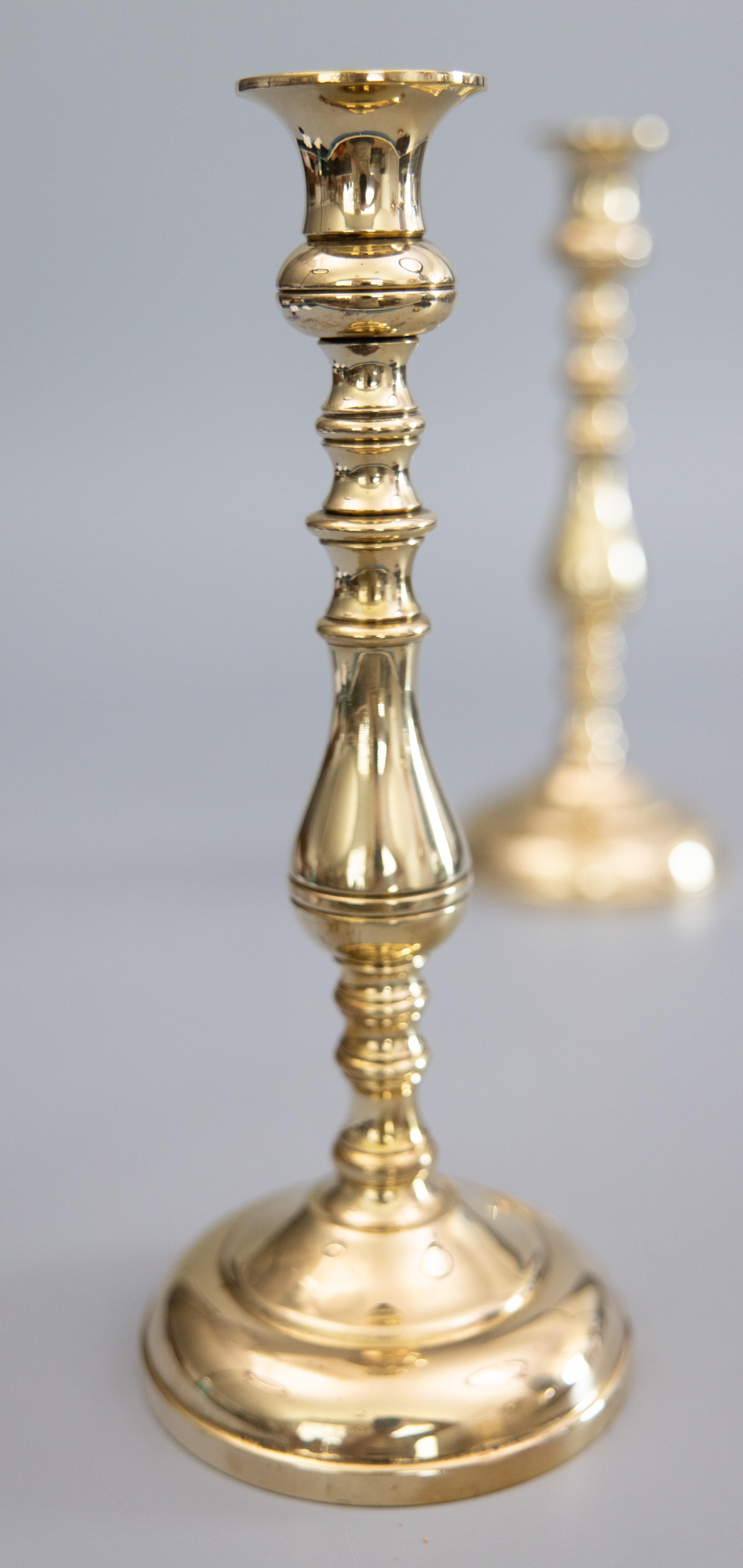 A fine tall pair of antique 19th-Century English Queen Anne style solid brass candlesticks with a lovely polished brass patina. These handsome candle holders are solid and heavy, together weighing over 5 lbs, and they display