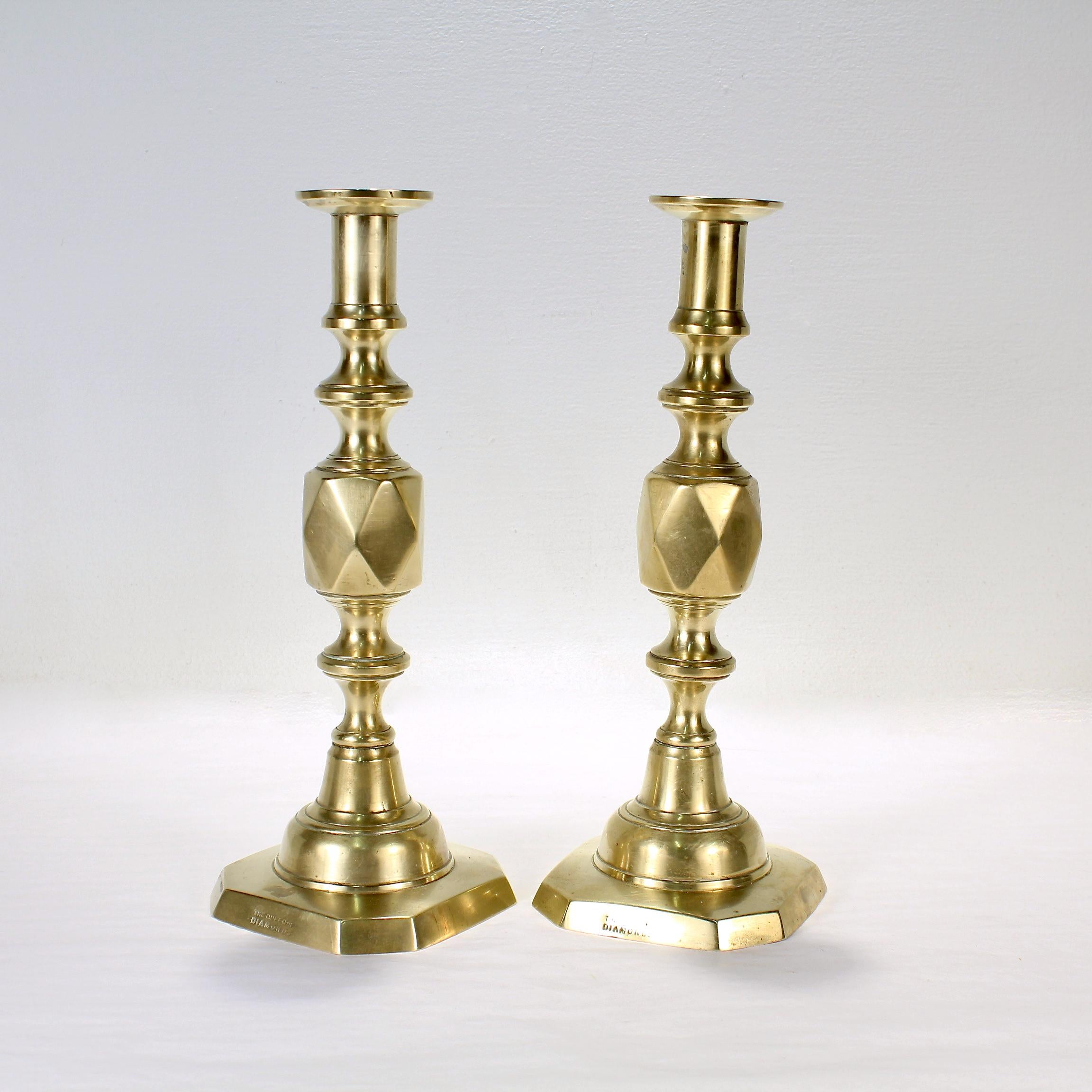 A pair of fine antique English brass candlesticks.

In the 'Queen of Diamonds' pattern by James Clews & Sons. 

James Clews & Sons of Birmingham designed the Diamond series of candlesticks to celebrate the Diamond Jubilee of Queen Victoria in