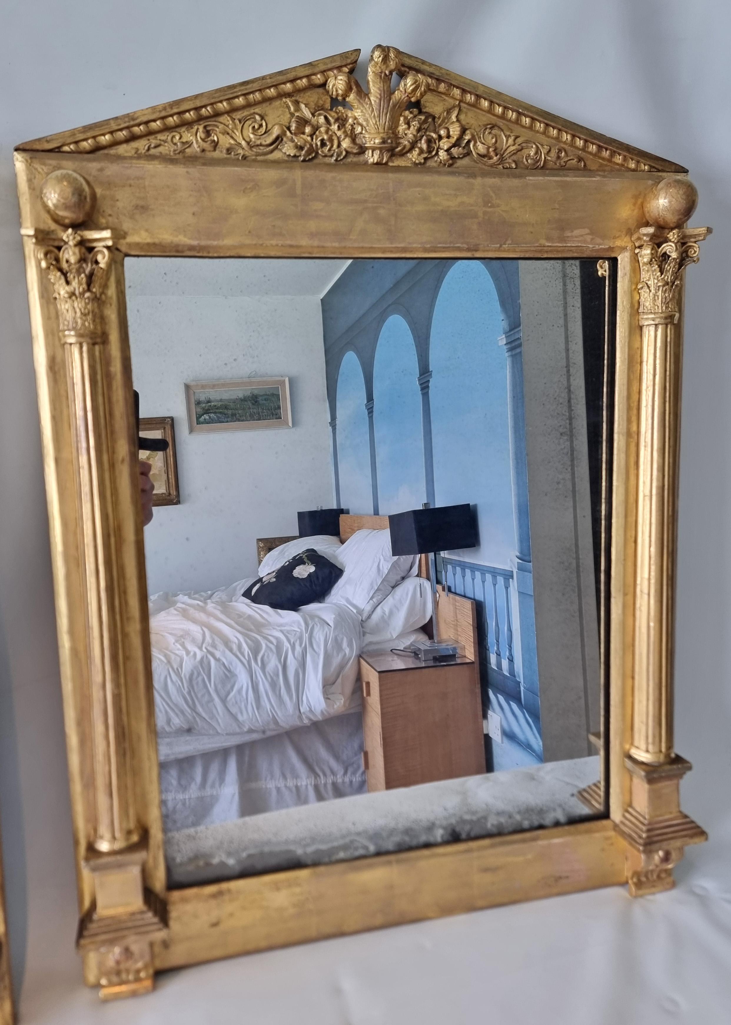 Superbe paire de miroirs de forme classique de style Régence anglaise. Les colonnes cannelées à base carrée sont surmontées de chapiteaux superbement sculptés. Le fronton est sculpté, doré et orné de plumes de Prince de Galles. Verre d'origine dans