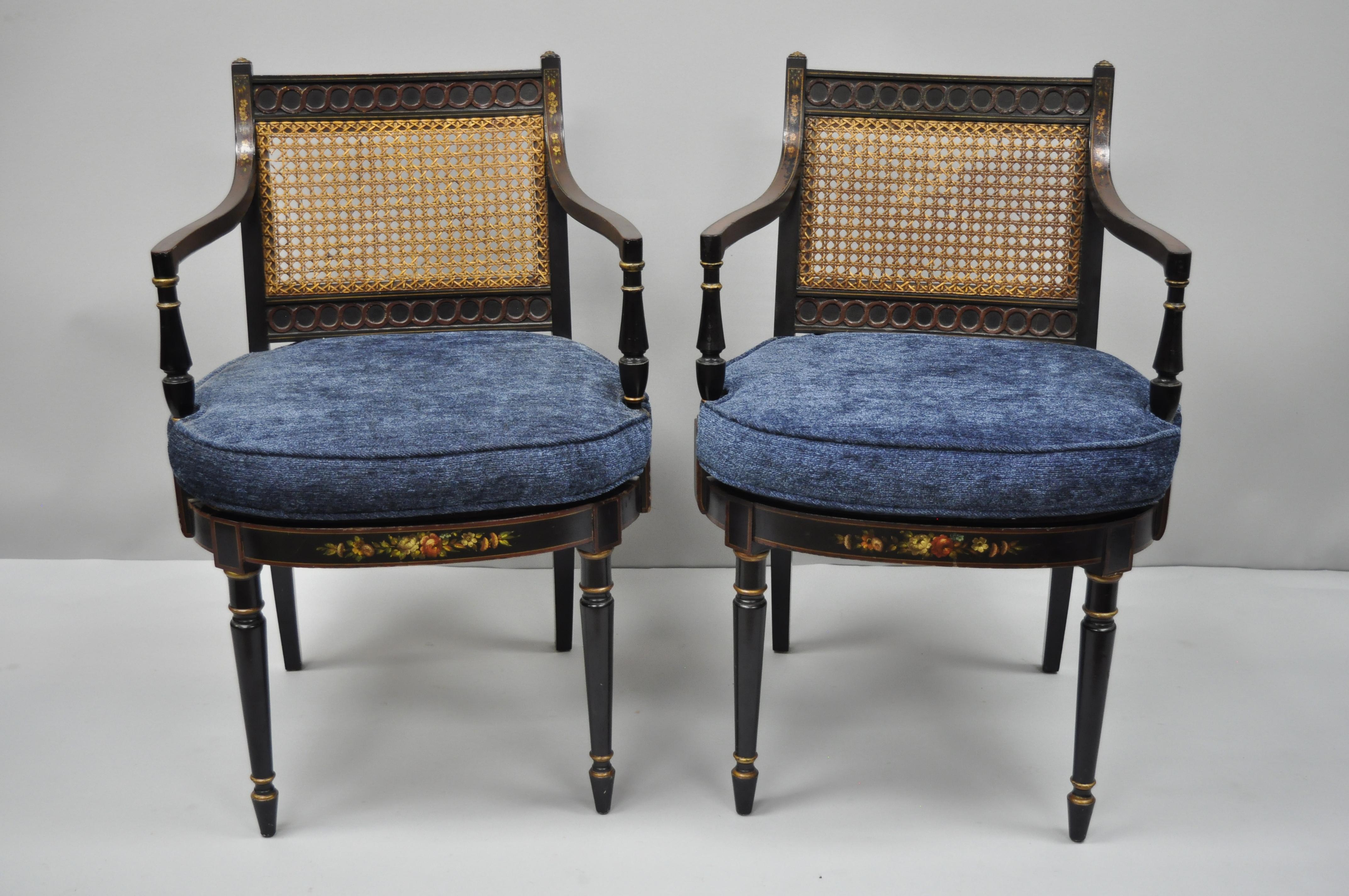 Pair of antique English regency style black lacquer cane armchairs. Items feature blue loose cushions, cane back and seats, hand painted floral accents, black lacquer finish, circa early 20th century. Measurements: 33