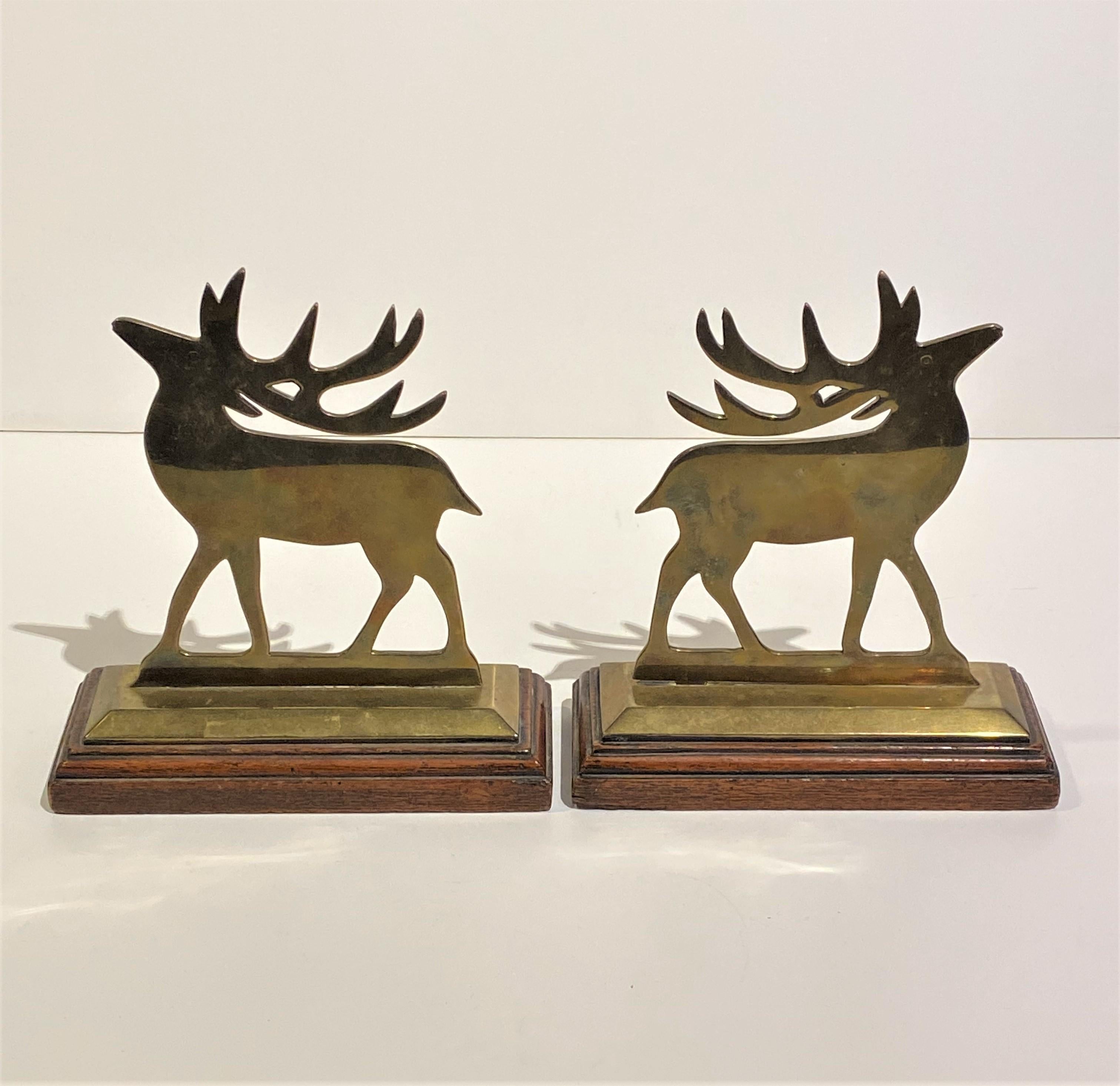 A wonderful unique pair of old solid brass Reindeer chimney ornaments on Oak stands from England.  Circa 1860.