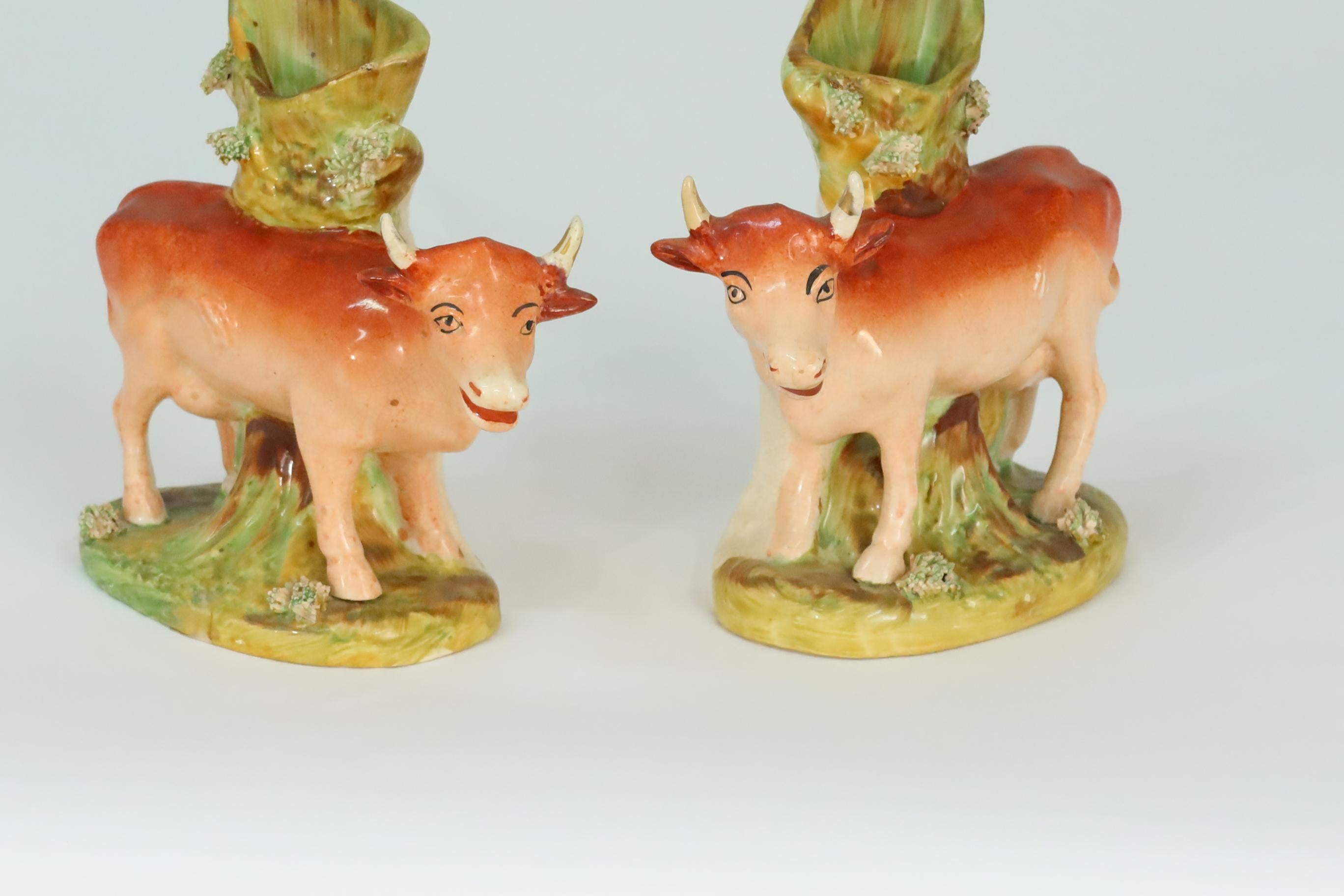 A fine pair of antique English Staffordshire cow spill vases with strong coloration and very good condition. Some gilt decoration is applied to the horns, circa 1840 (From the owner's private collection).