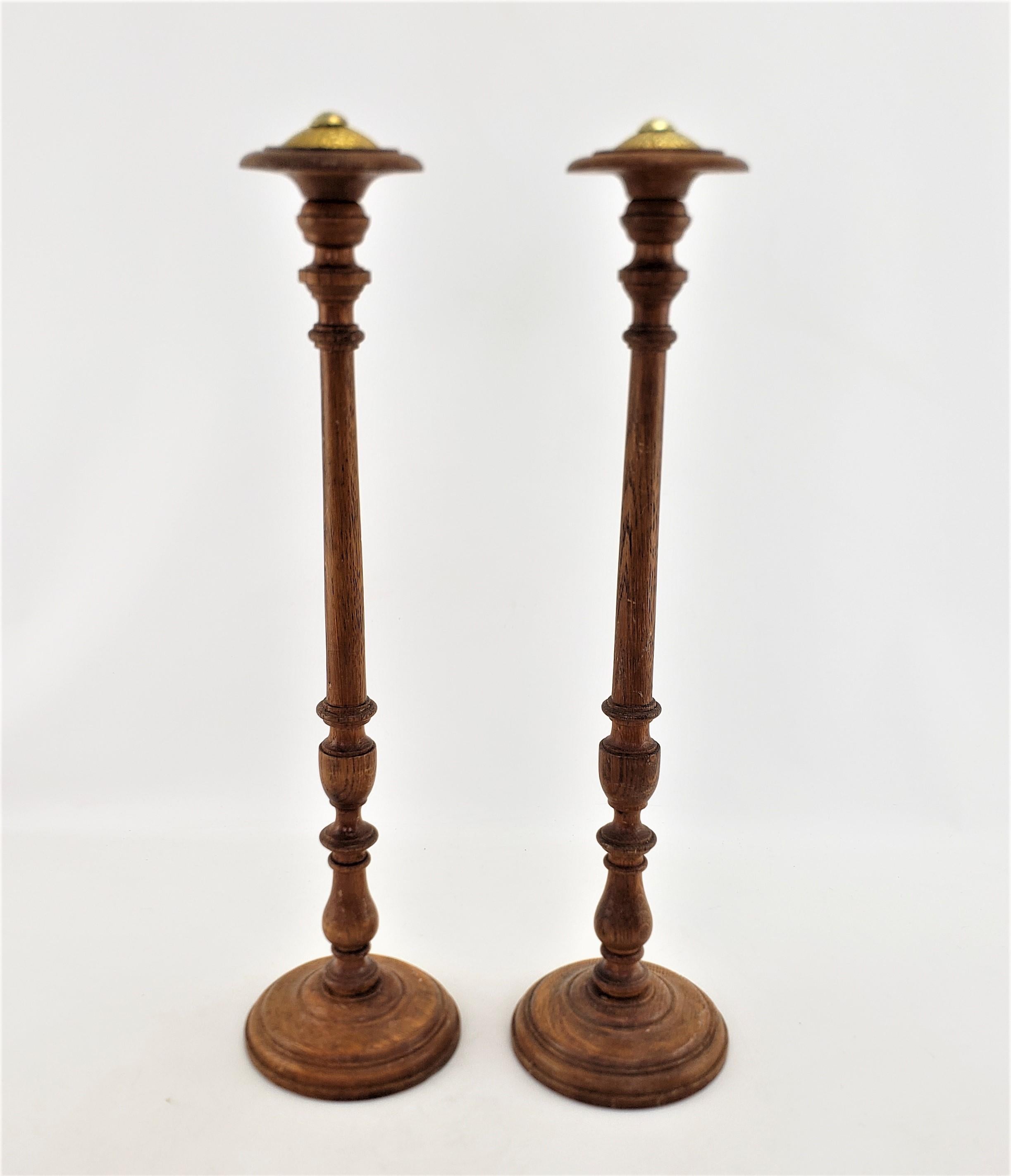 This pair of antique turned mercantile hat stands are unsigned but presumed to originate from England and date to approximately 1880 and done in a period Victorians style. The shafts and base are composed of solid oak with have been lath turned in