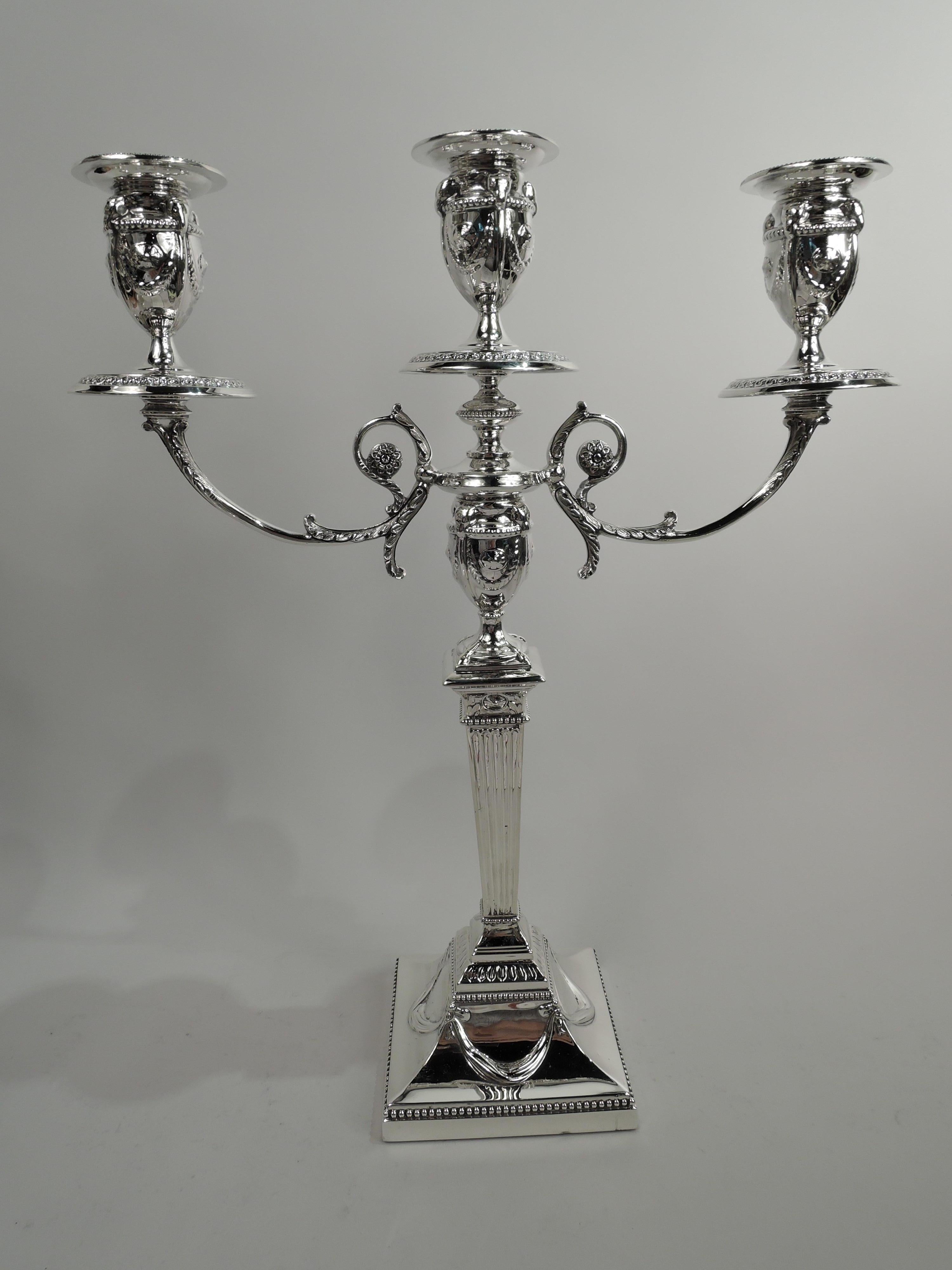 Pair of Victorian neoclassical sterling silver 3-light candelabra. Made by Walker & Hall in Sheffield in 1898. Tapering and fluted shaft on raised square foot. Central socket on knopped base to which are mounted two leaf-capped and -wrapped scrolled
