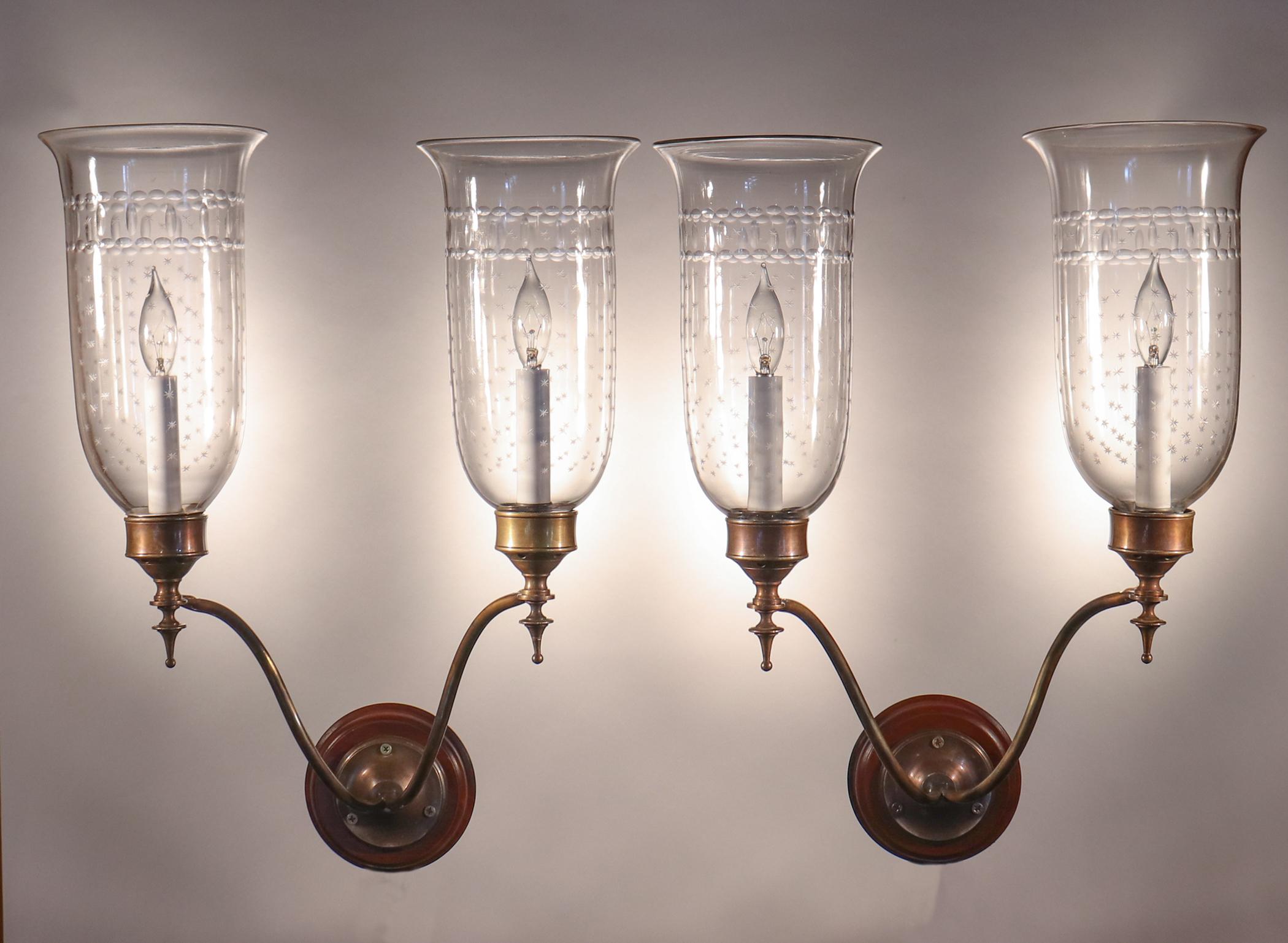 A set of four, gracefully flared hurricane shades from England, circa 1900. These hand blown glass shades have a finely etched 