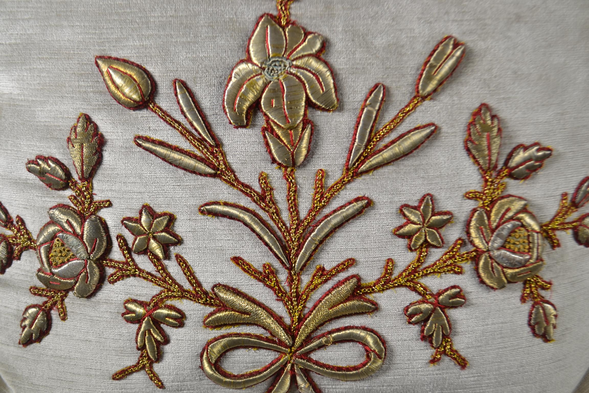 Pair of antique European raised gold metallic embroidery, couched with red silk thread on silver velvet. Hand trimmed with gold metallic cording knotted in the corners, down filled.