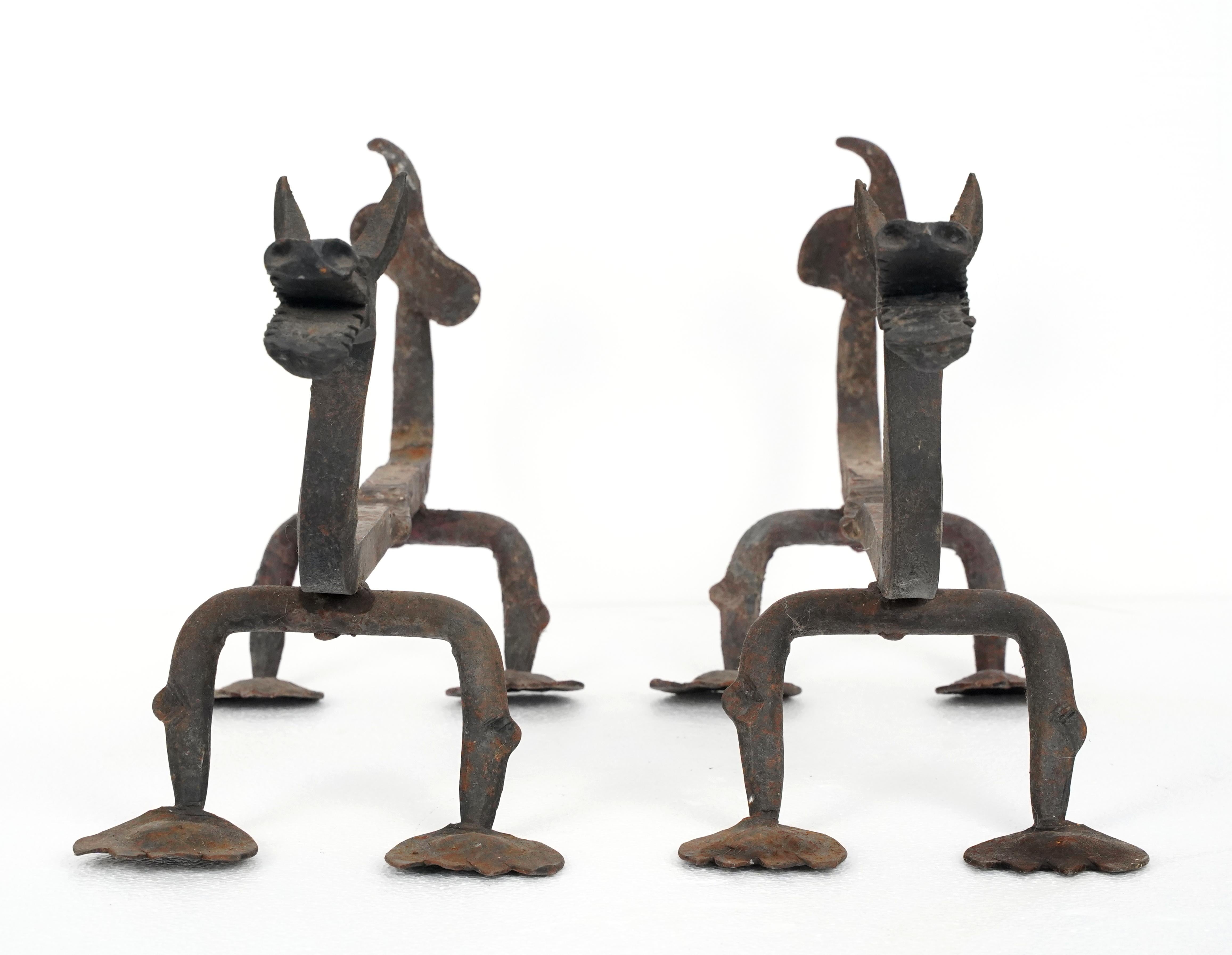 Antiguos morillos de chimenea europeos de hierro forjado con acabado negro. Estos morillos presentan un motivo de dragón con cuellos curvados, cabezas cornudas y bocas abiertas. Su cuerpo es sencillo, con cuatro patas de pies redondeados. Buen