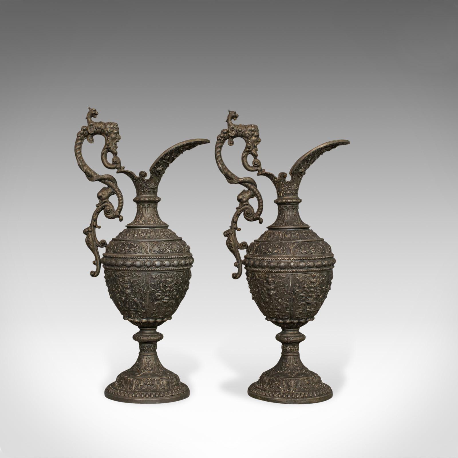 This is a pair of antique ewers in classical taste. Two French, decorative bronze spelter water jugs or wine pitchers and dating to the late 19th century, circa 1890.

Of impressive, highly decorated classical taste - perfect for Fine