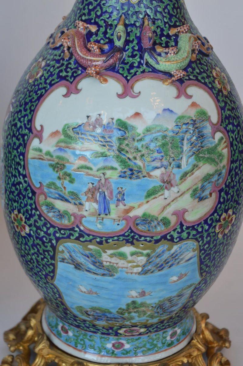 Paire de vases anciens de la famille rose avec des dragons et des chiens de foo appliqués. Forme rare et fond bleu cobalt, vers 1900.