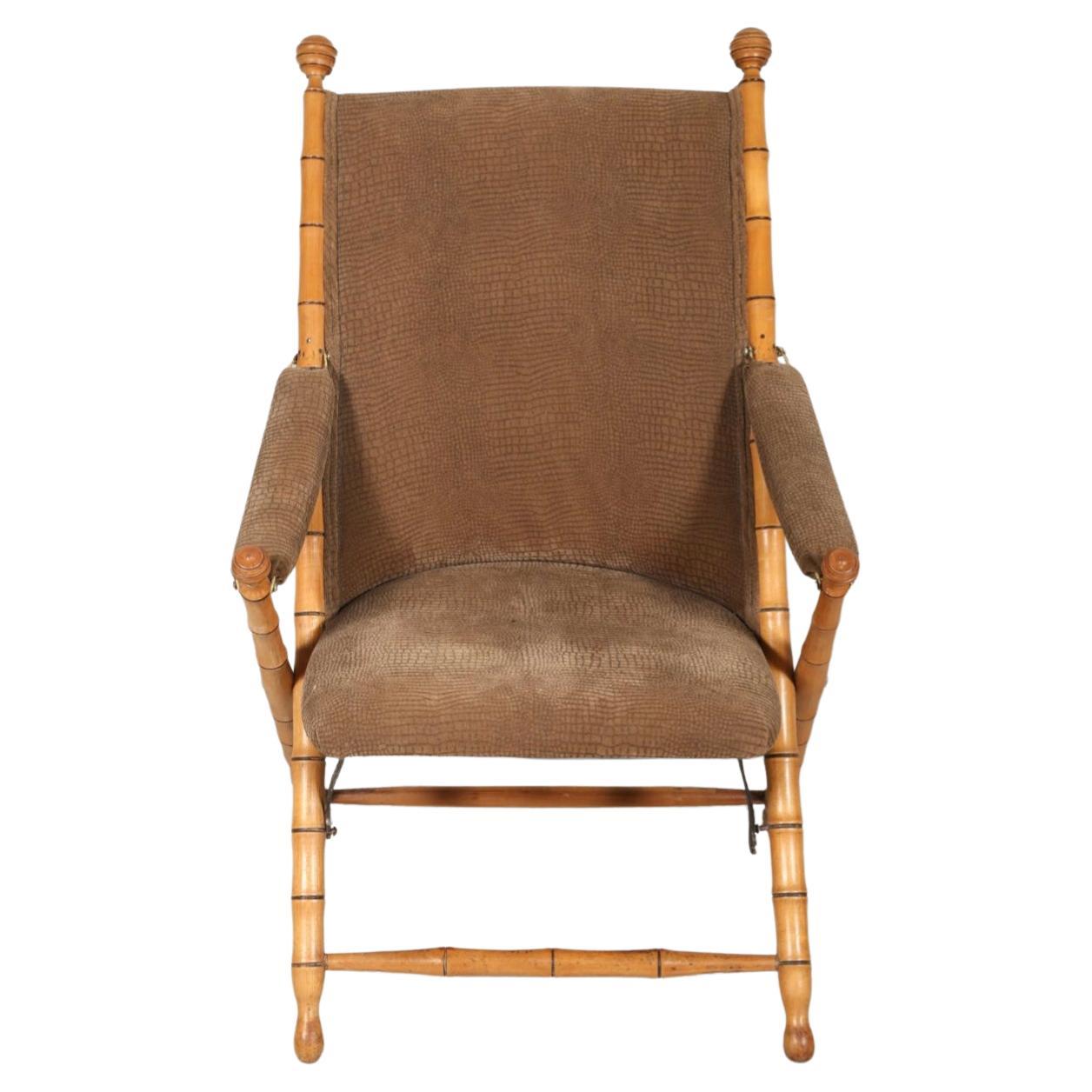 A magnificent pair of folding campaign chairs, made in France. The frames have been expertly carved to mimic bamboo, as chinoiserie was all the rage at the time. 
Late 19th or early 20th century lounge chairs with padded fabric back, seat and arm