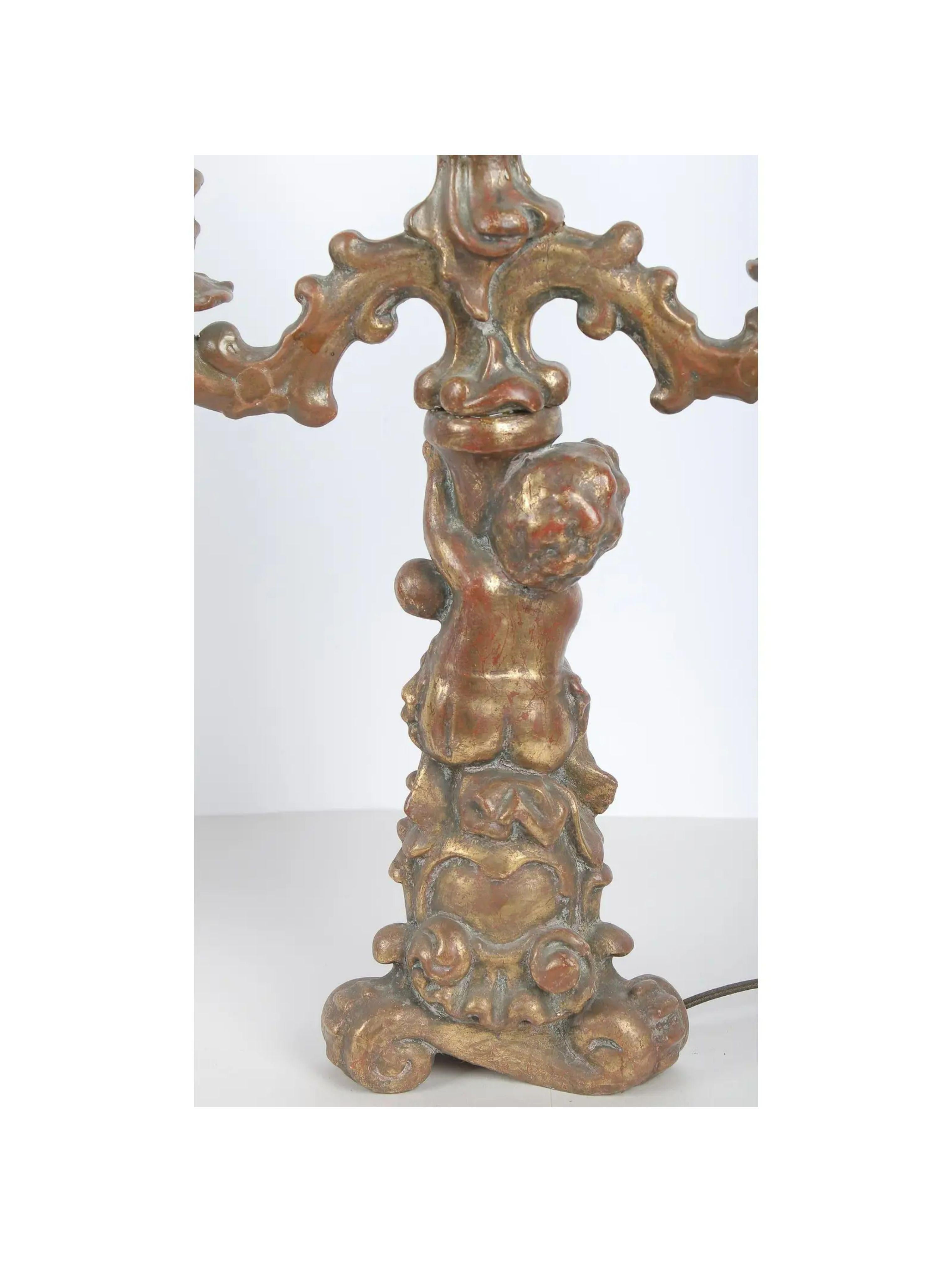 Pair of Antique Figural Nude Putti Gilt Wood Candelabra Lamp. Height to the top of the base is 20 inches.

Additional information: 
Materials: Wood
Color: Gold
Period: Early 20th Century
Styles: Figurative, French
Lamp Shade: Not Included
Power