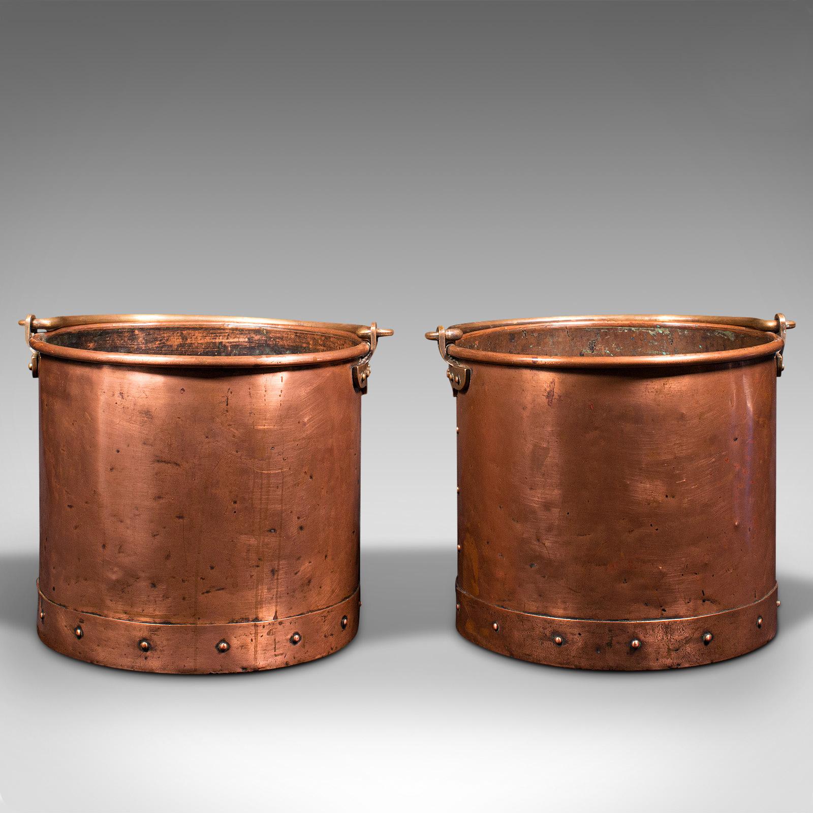 This is a pair of antique fireside bins. An English, copper coal or fire bucket, dating to the Victorian period, circa 1860.

Wonderfully unusual as a pair with superb colour
Displaying a desirable aged patina and good antique order
Copper body