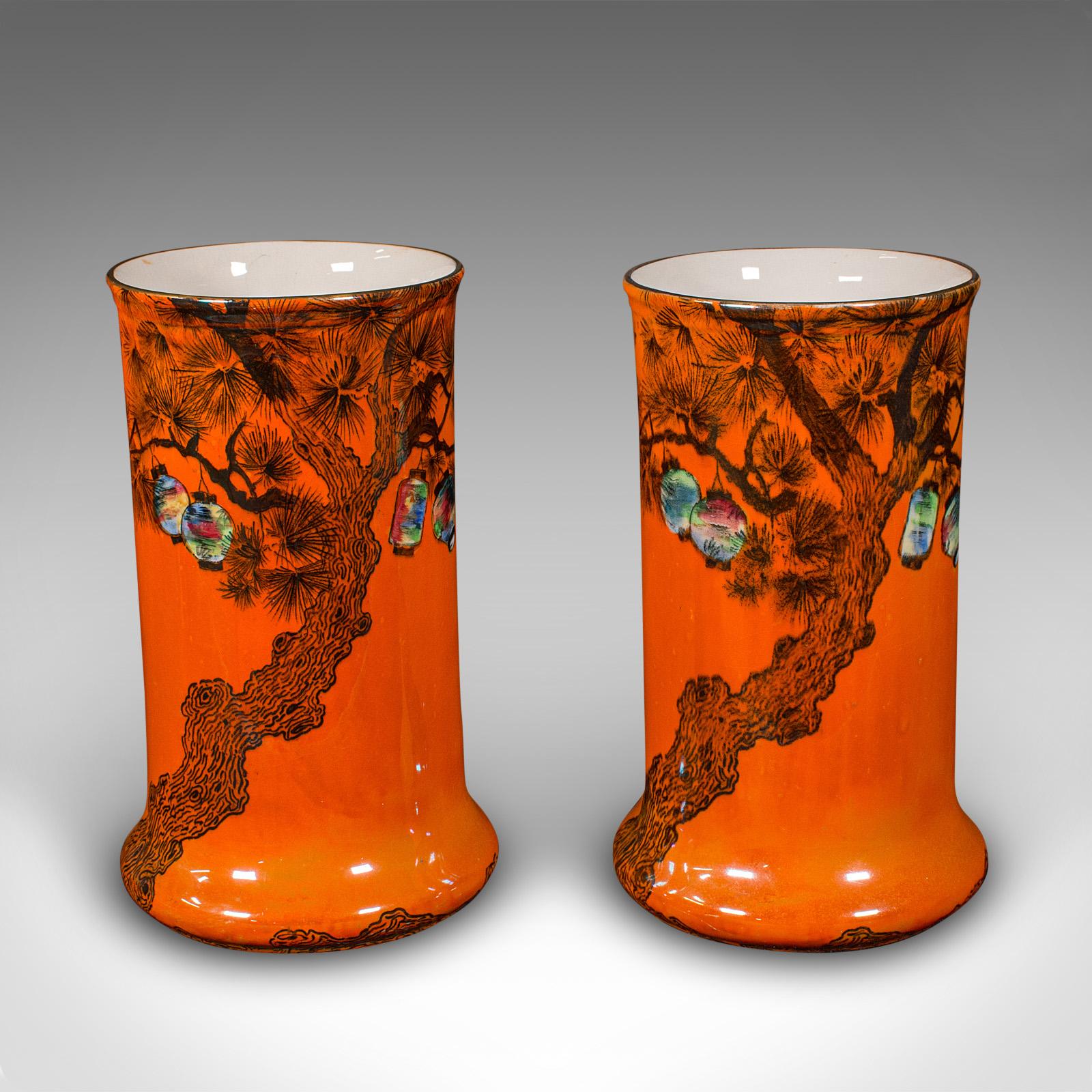 
This is a pair of antique flower vases. An English, lustre glaze ceramic sleeve with Oriental taste, dating to the early 20th century, circa 1920.

Dashing colour accentuated with an Oriental motif
Displaying a desirable aged patina and in good