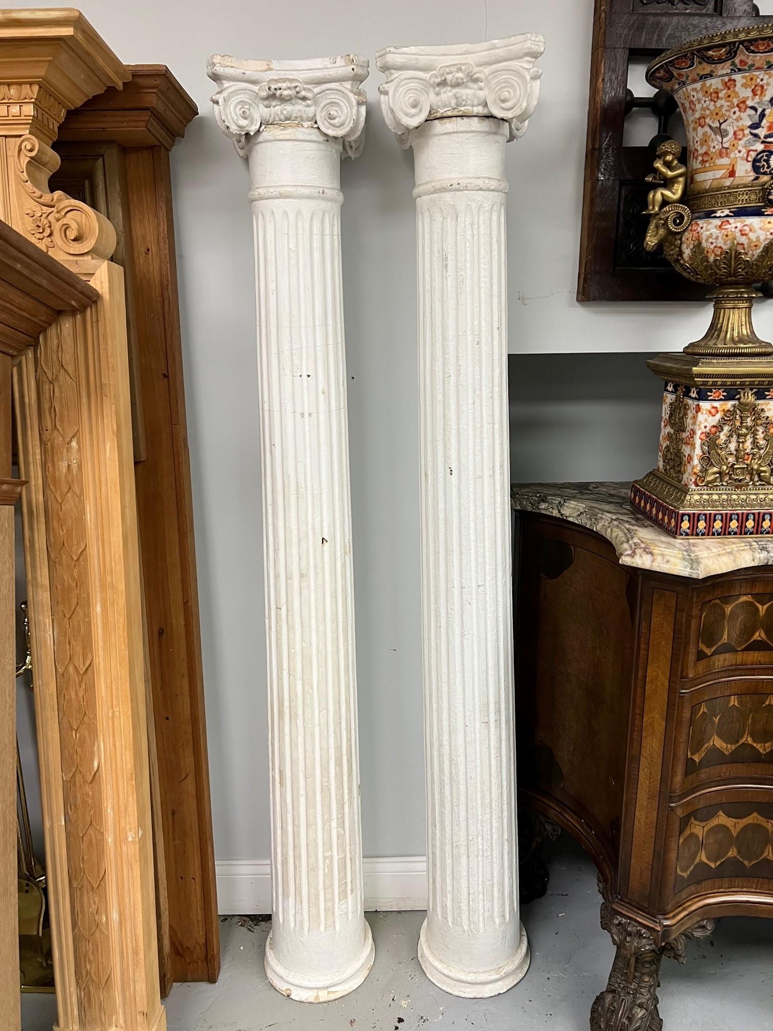 A nice pair of early 20th century American architectural fluted wood columns with Ionic capitals. The capitals are made of a composition maybe plaster and the columns are wood. This pair of columns would look great on either side of an entrance or
