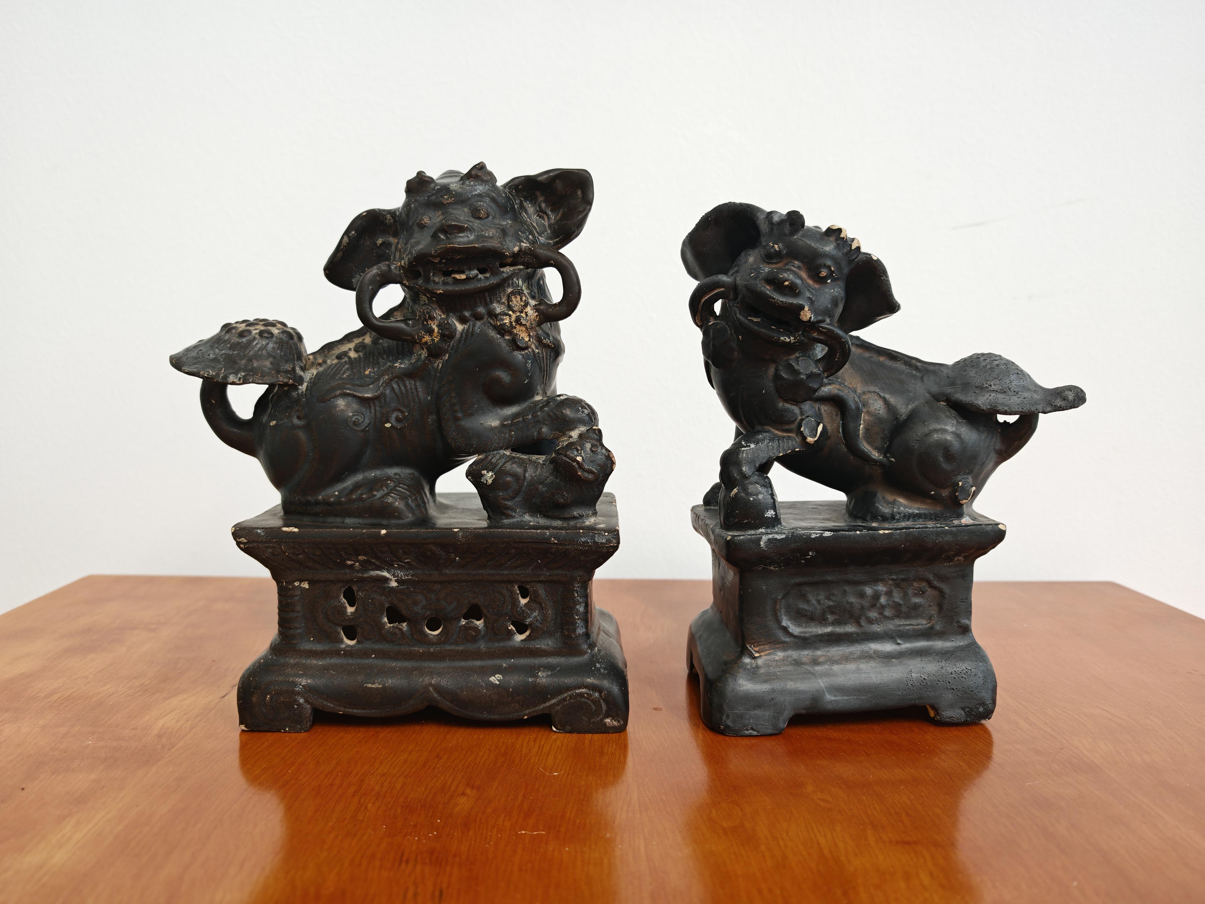 Dans cette annonce, vous trouverez une paire de chiens Foo Antique en céramique peinte en noir. En y regardant de plus près, les figurines montrent les restes du placage d'or - les taches d'or 24K, nous montrant que les pièces étaient entièrement