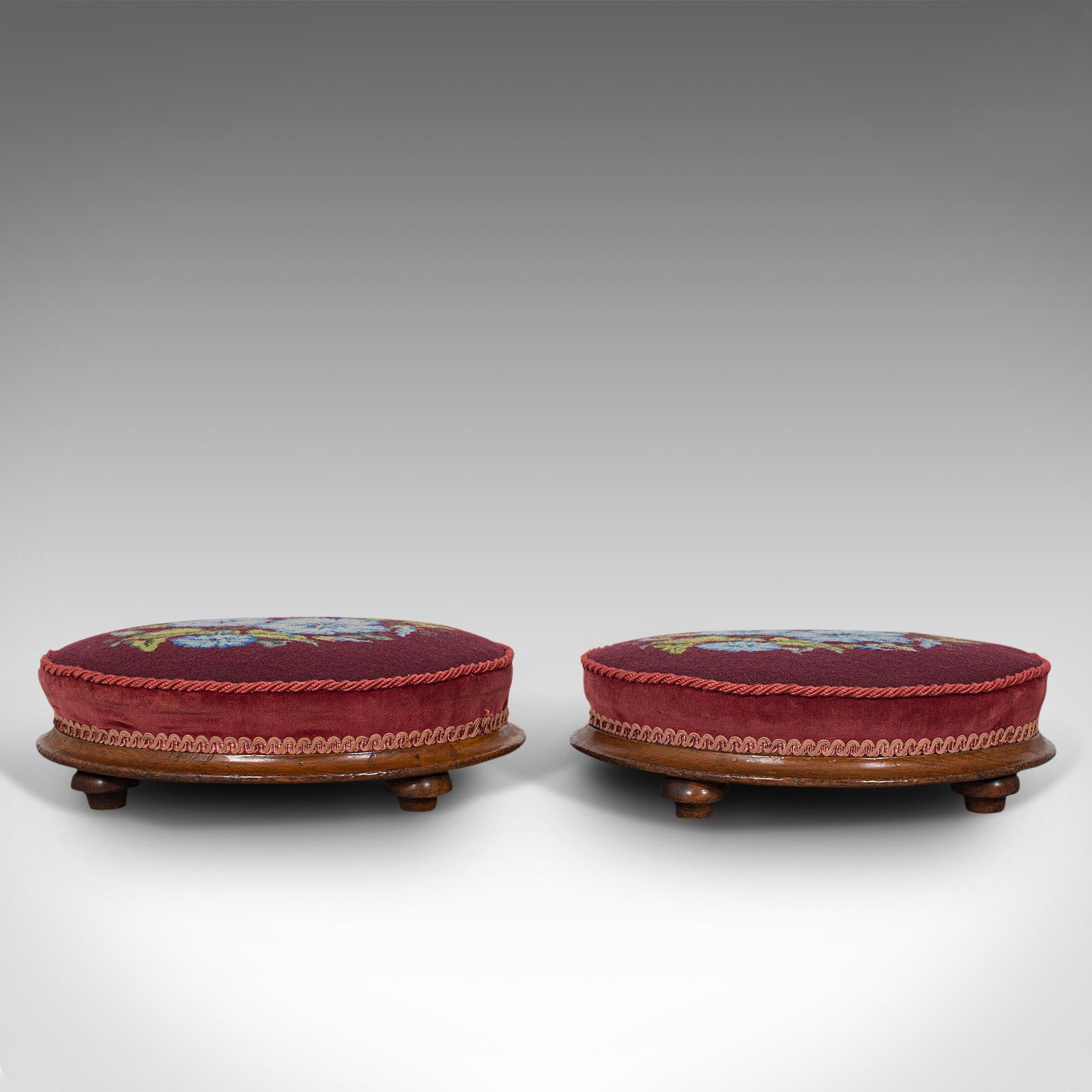 This is a pair of antique footstools. An English, walnut and needlepoint rest, dating to the mid Victorian period, circa 1860.

Of generous size for resting one's feet
Displaying a desirable aged patina, in very good order
Walnut bases show fine