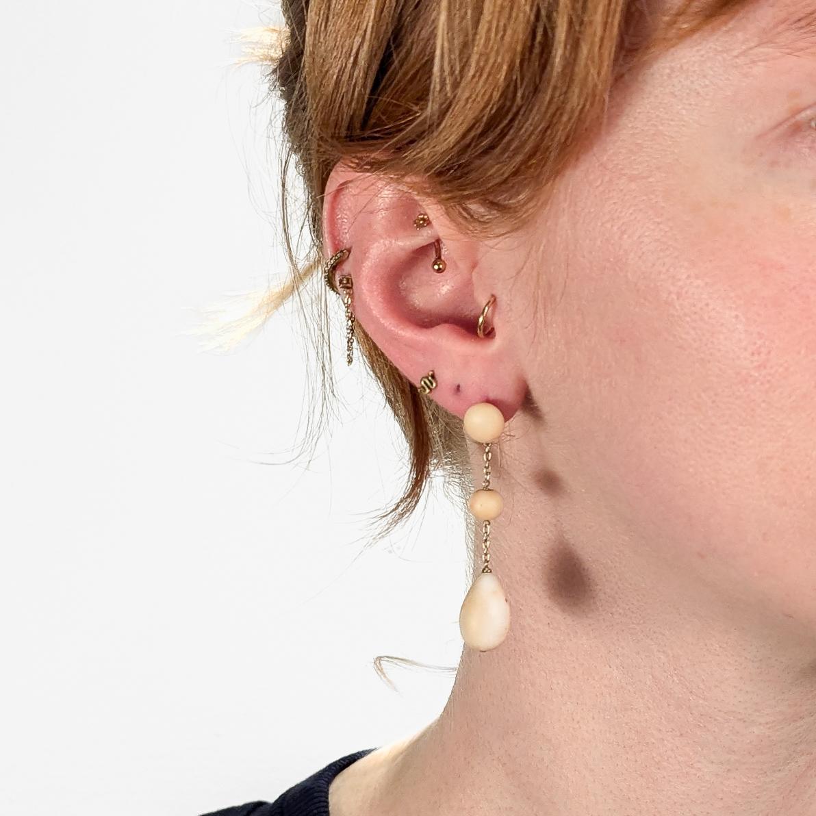Ein schönes Paar französischer Ohrringe mit Anhänger oder Kronleuchter.

Aus 18 Karat Gelbgold.

Jeweils mit einer birnenförmigen, einer runden und einer knopfförmigen Korallenperle.

Die Perlen sind antikisiert und unpoliert.

An einer dünnen