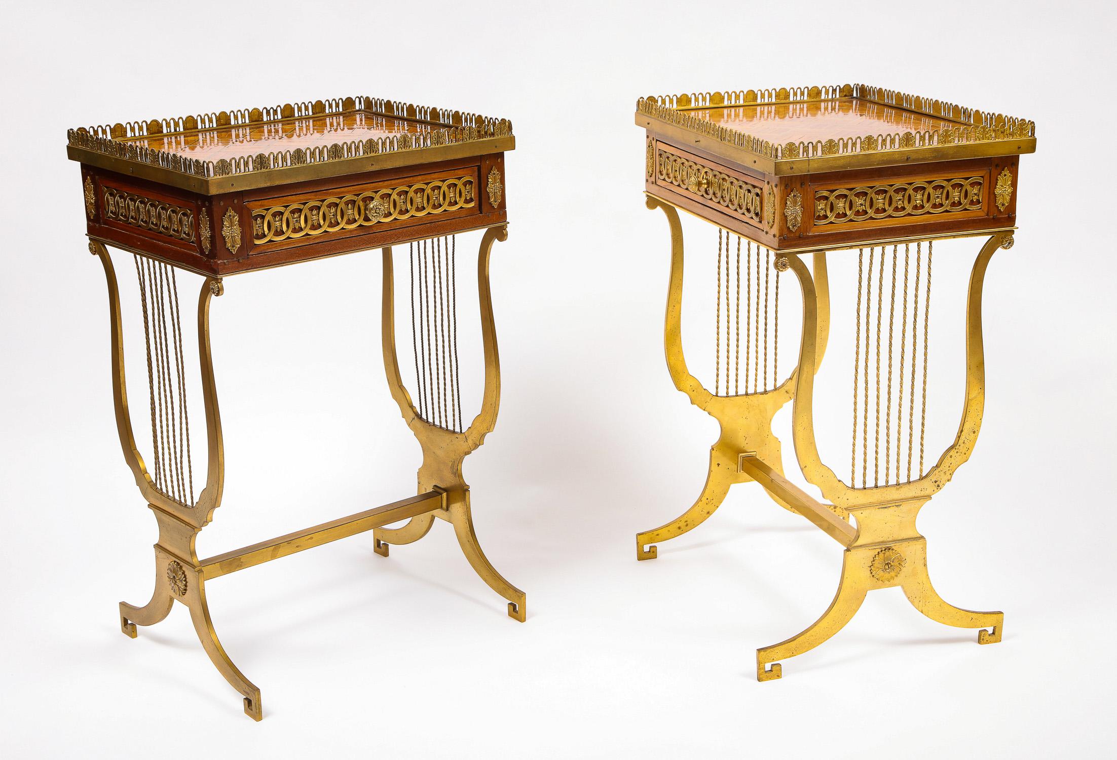 Magnífica pareja de antiguas mesas auxiliares/centrales francesas de estilo Luis XVI de forma rectangular con patas de bronce en forma de lira. El bronce dorado, bellamente cincelado a mano, está presente en todas las mesas, incluso alrededor del