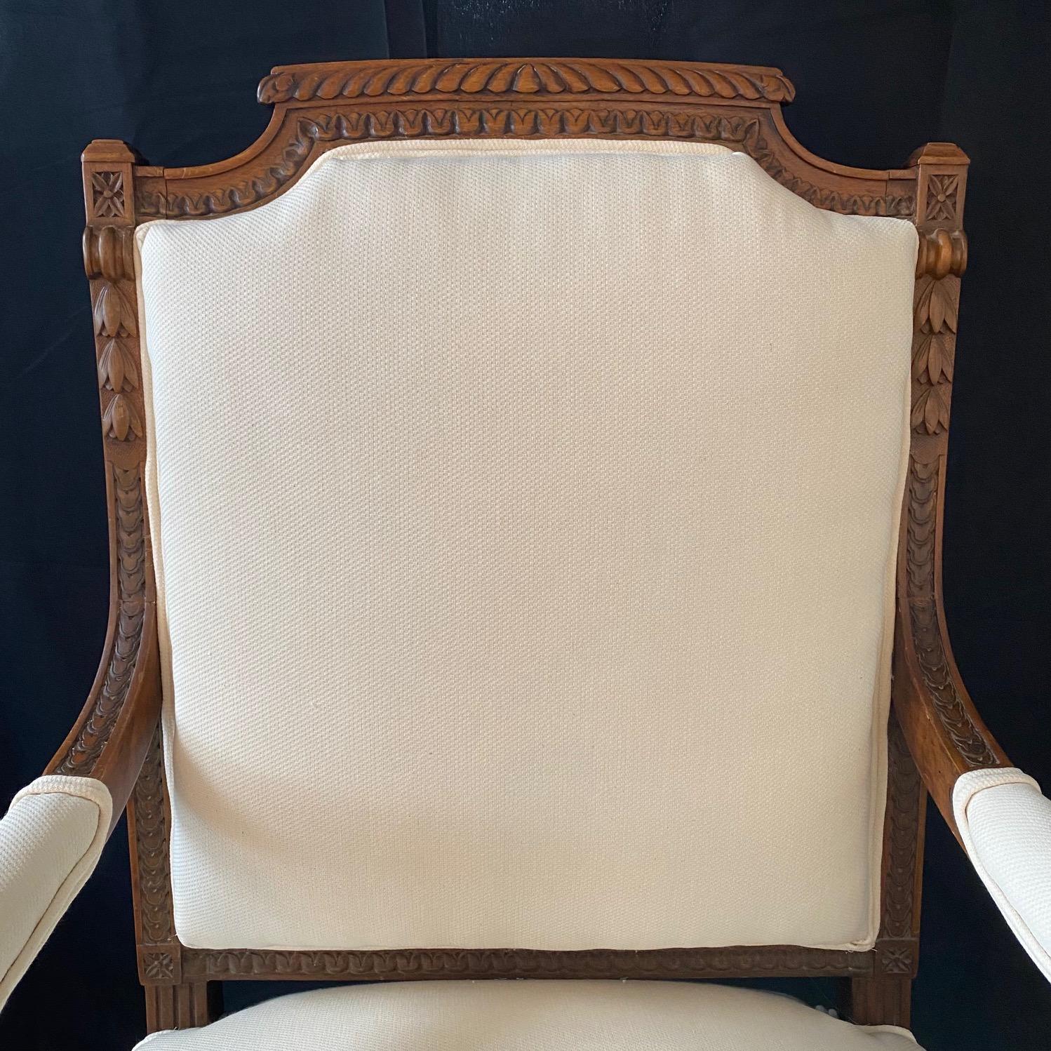 Beautifully carved exquisite neoclassical pair of walnut French chairs handcrafted in the early 19th century.  Each chair consists of an elegantly carved wood frame with acanthus leaves and corner florets, with all new linen blend high end