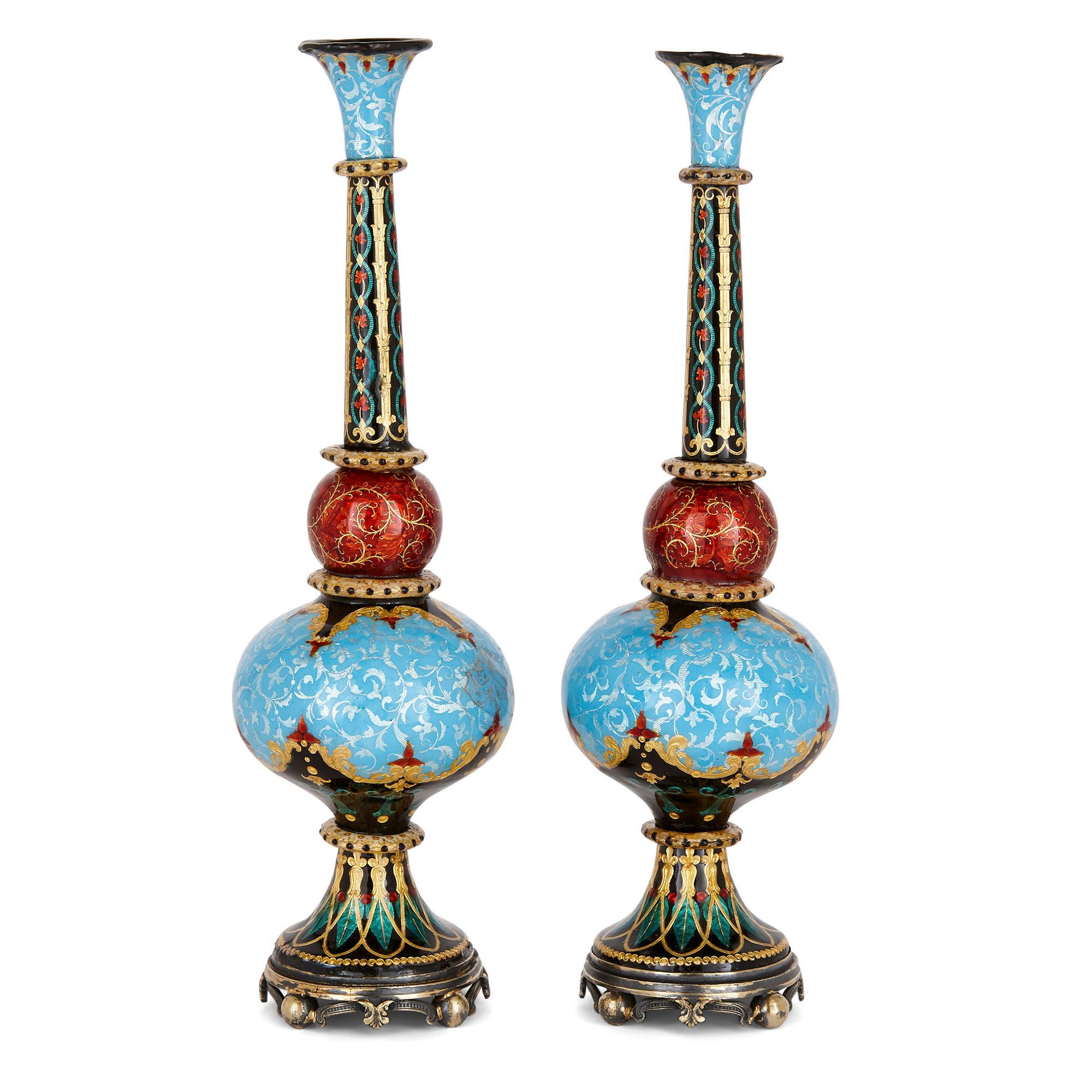 Pair of antique French arabesque enamel vases for Turkish Export
French, late 19th century
Dimensions: Height 20cm, diameter 6cm

These two unusual vases are beautifully crafted from polychrome enamelled bodies, with parcel gilt and arabesque