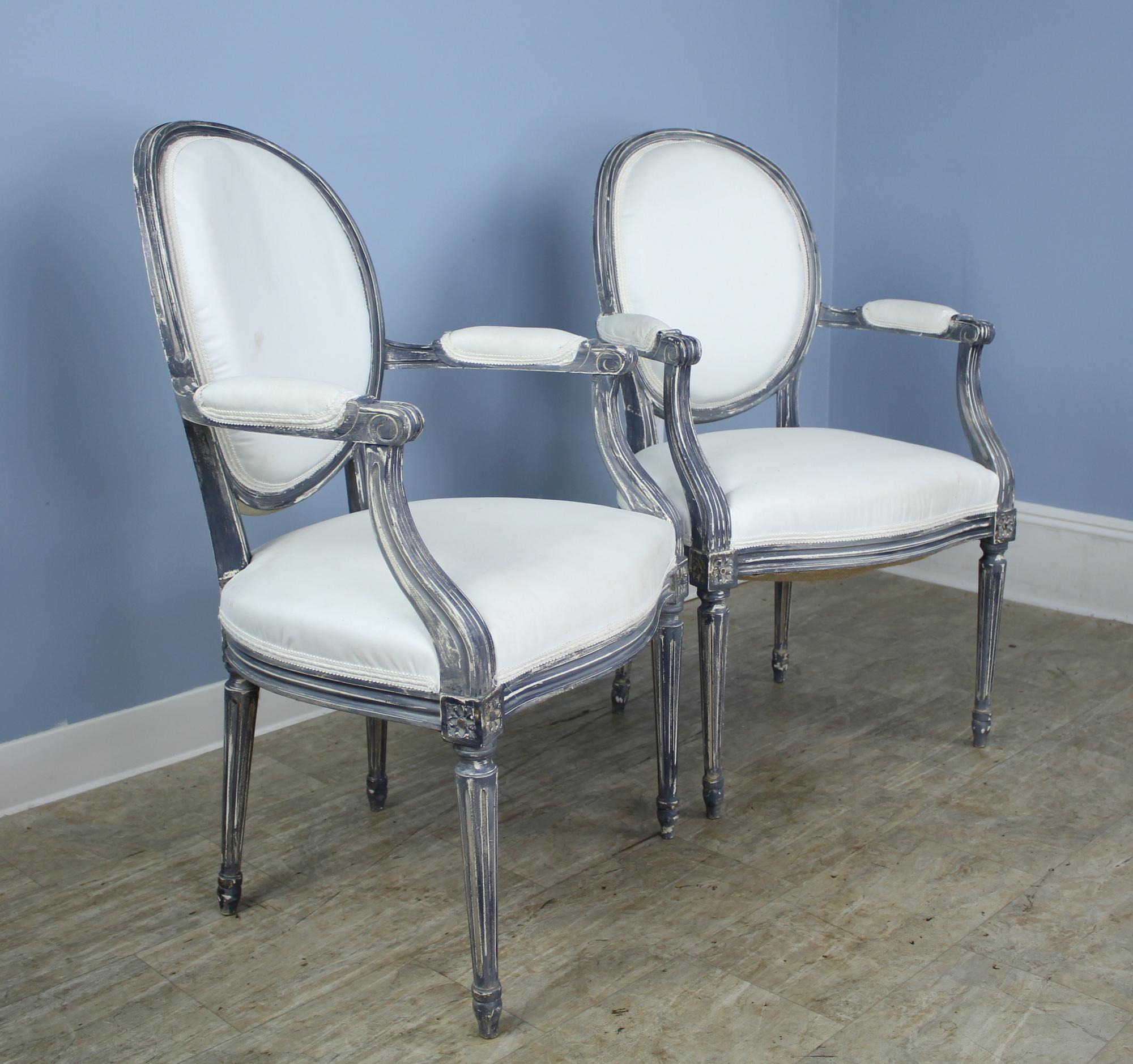 Pair of antique occasional chairs from France. These side chairs have been recently overpainted in gray and white to showcase their detailed carving. Ready for upholstering. Quite sturdy and comfortable.