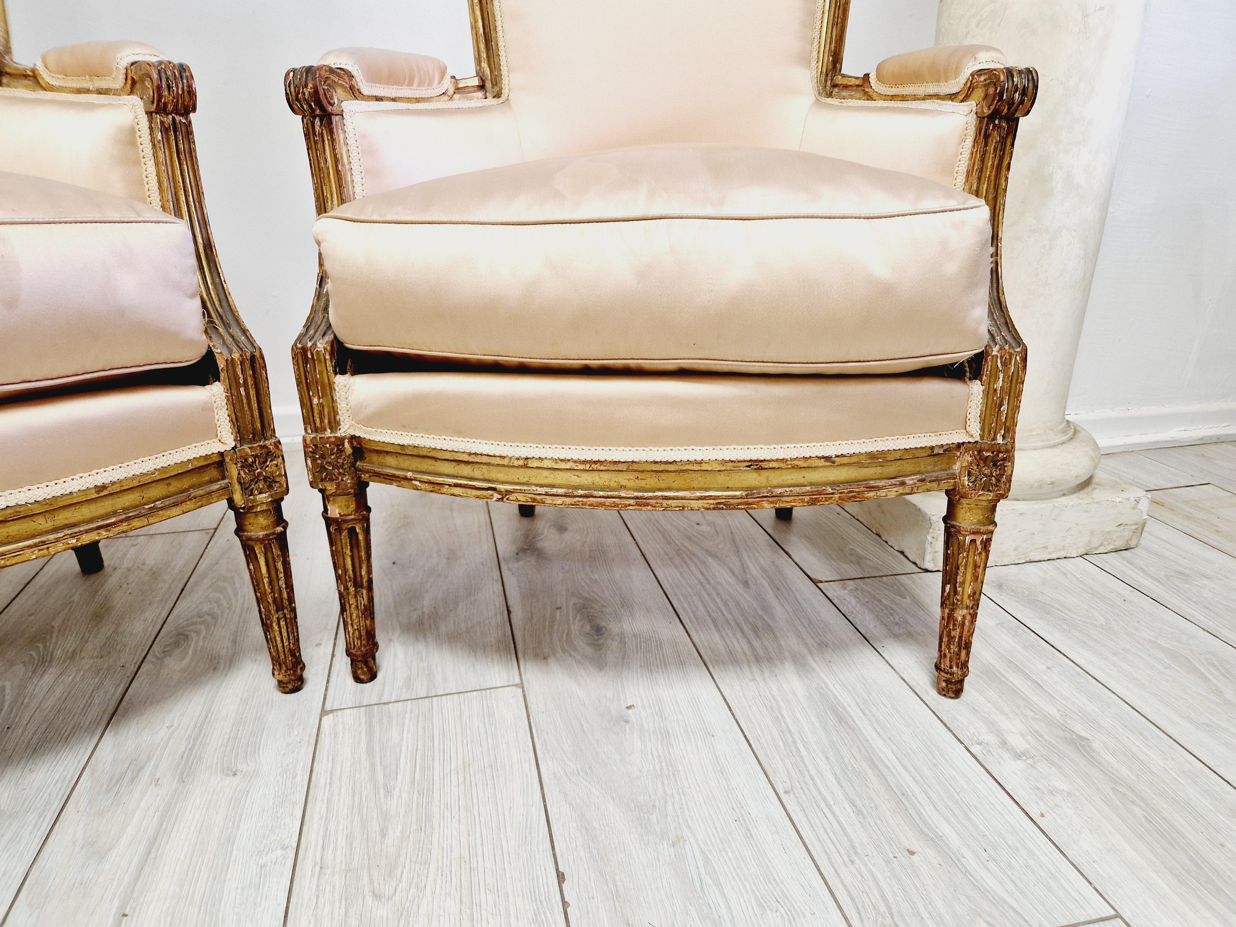 Add an elegant touch to your living space with this beautiful pair of antique Bergere armchairs. Crafted by hand in France in 1780, these chairs boast a stunning gilded finish and with a nude cotton upholstery, ensuring maximum comfort and