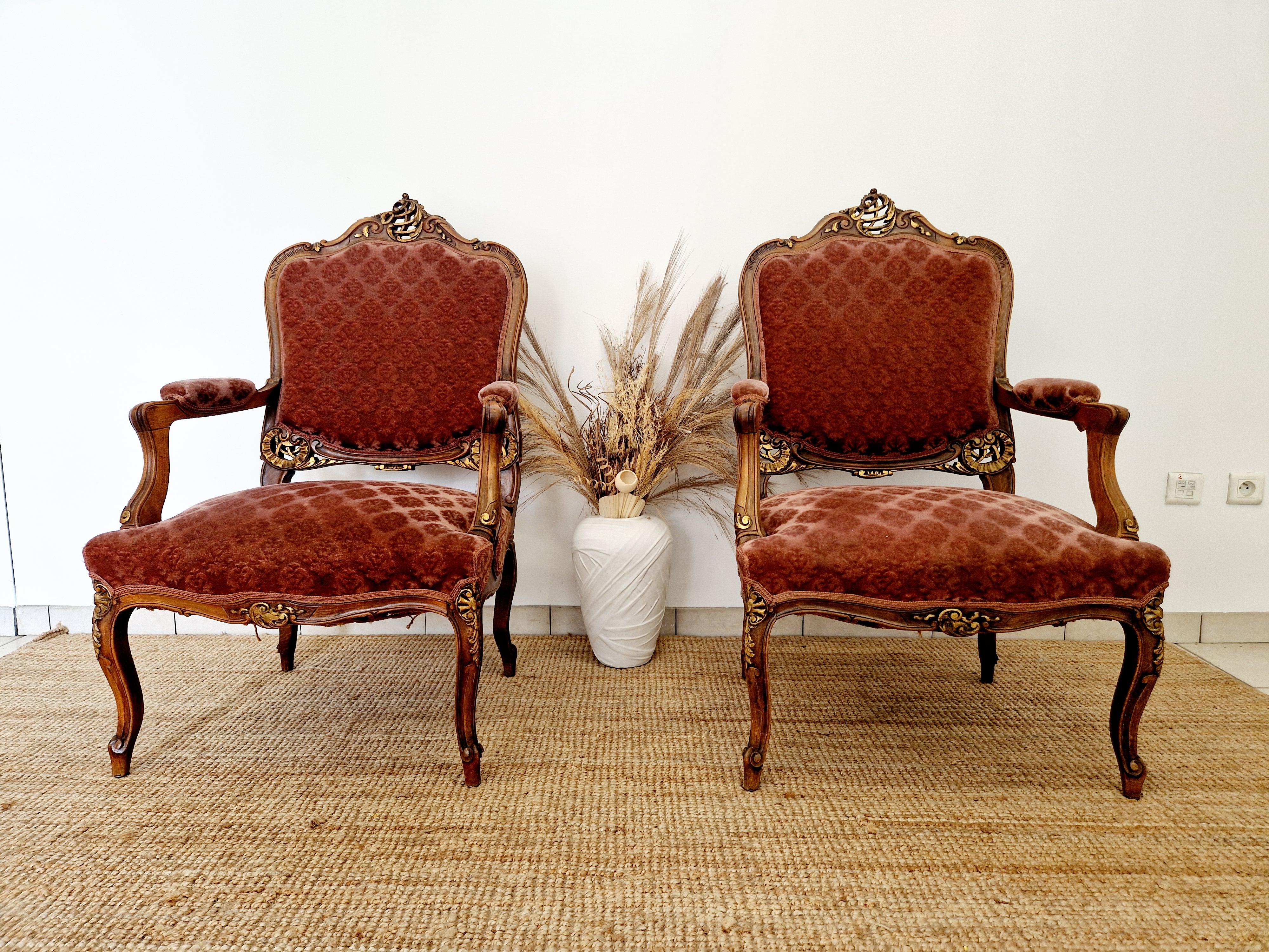 Questo  è una coppia unica di antiche poltrone Bergere in stile Luigi XV, realizzate a mano in Francia nel periodo 1800-1849. Le eleganti sedie di forma quadrata sono caratterizzate da una finitura media con accenti dorati e da un solido tessuto di