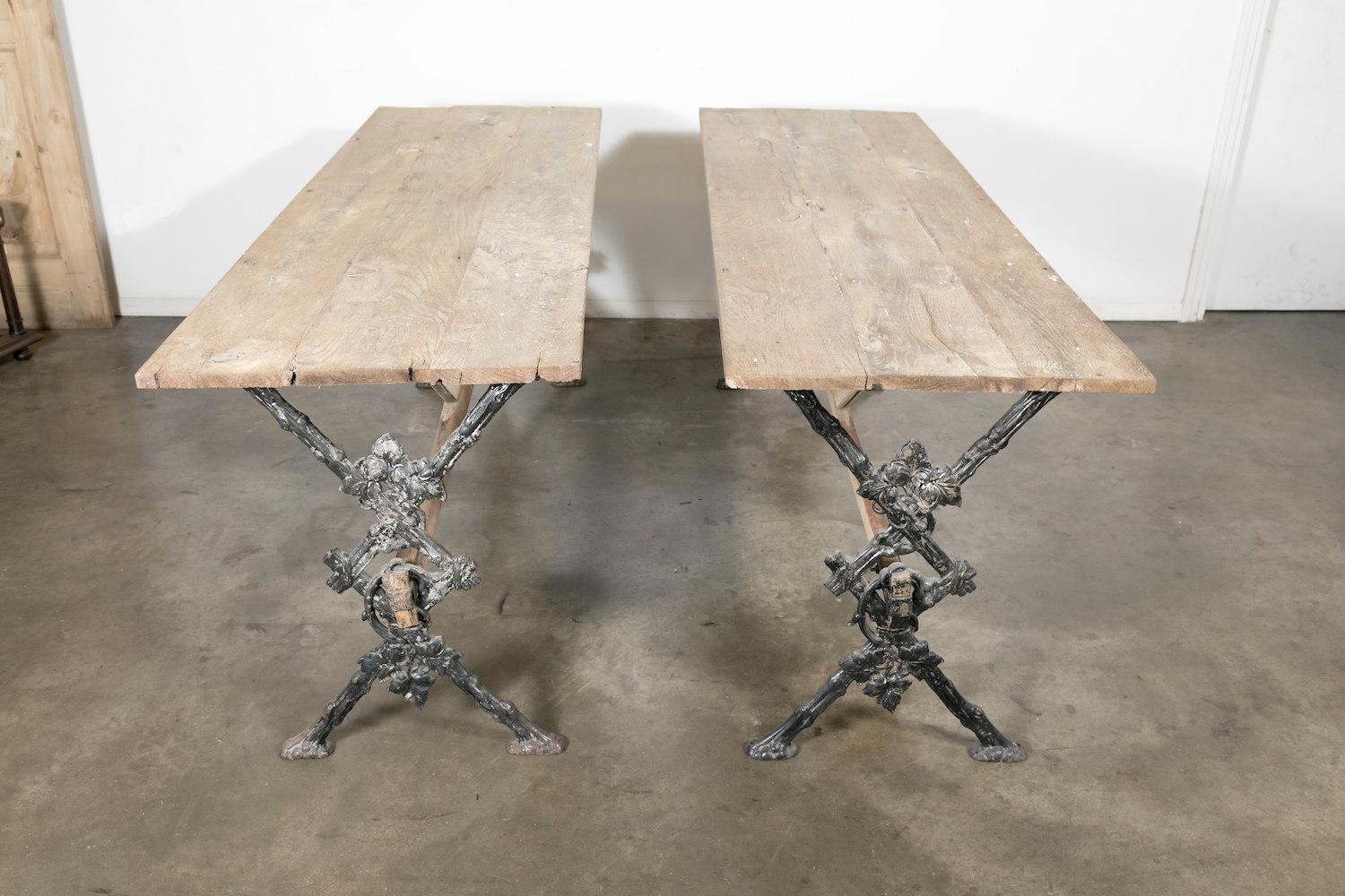 Charming early 20th century bistro table from Bordeaux, having a rustic washed oak top and cast iron legs with exceptional detail featuring fabulous grapevine and leaf decoration, joined by a wooden stretcher that provides additional stability. This