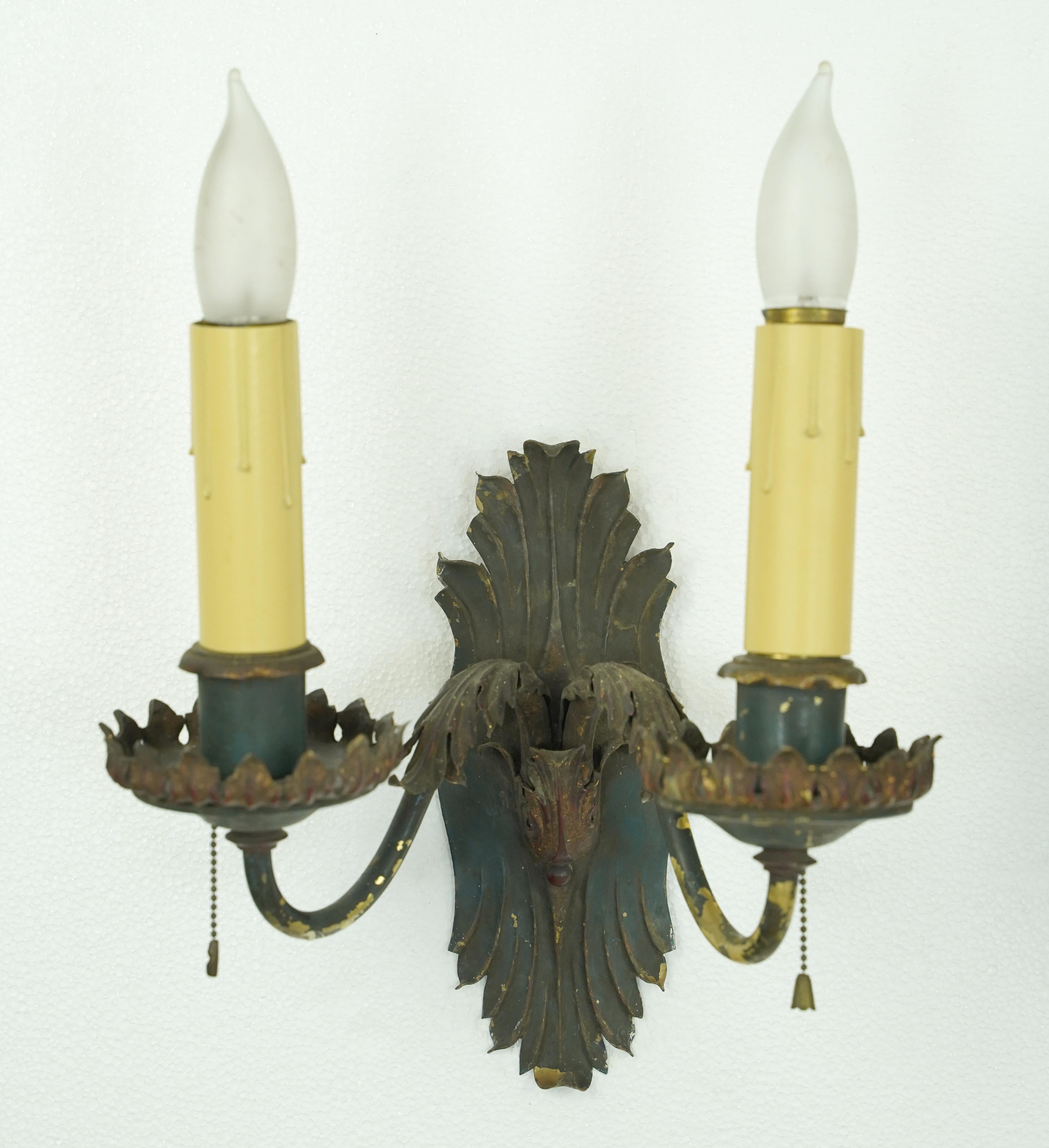 Antique pair of French style wall sconces made of brass painted black and red. Each sconce features two arms with its own pull chain. Each sconce requires two Edison style candelabra light bulbs. The price includes restoration of cleaning and