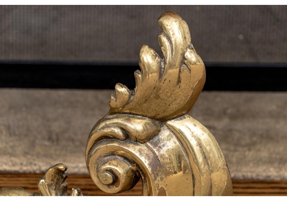 Finely cast French brass fireplace chenets in the form of tall scrolls with acanthus leaf decorated details in a high polish. With stepped iron bars at the back.

Dimensions: 10 1/2