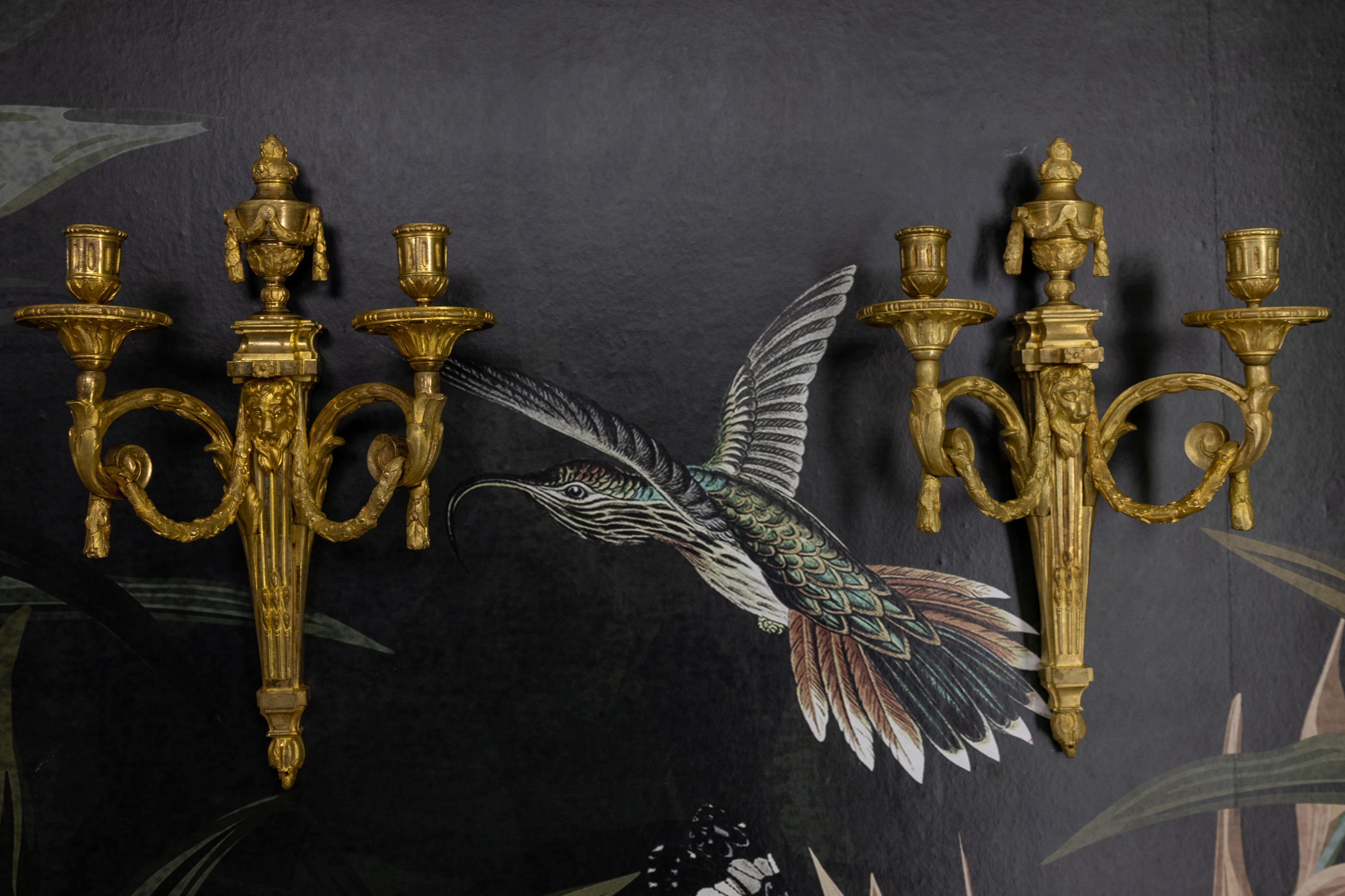Coppia di candelabri francesi a doppio braccio in bronzo antico con teste di leone, 1890 ca.

Eleva i tuoi interni con questa coppia di antiche candele da parete francesi, risalenti al 1890 circa. Impregnata di un'eleganza neoclassica senza tempo,
