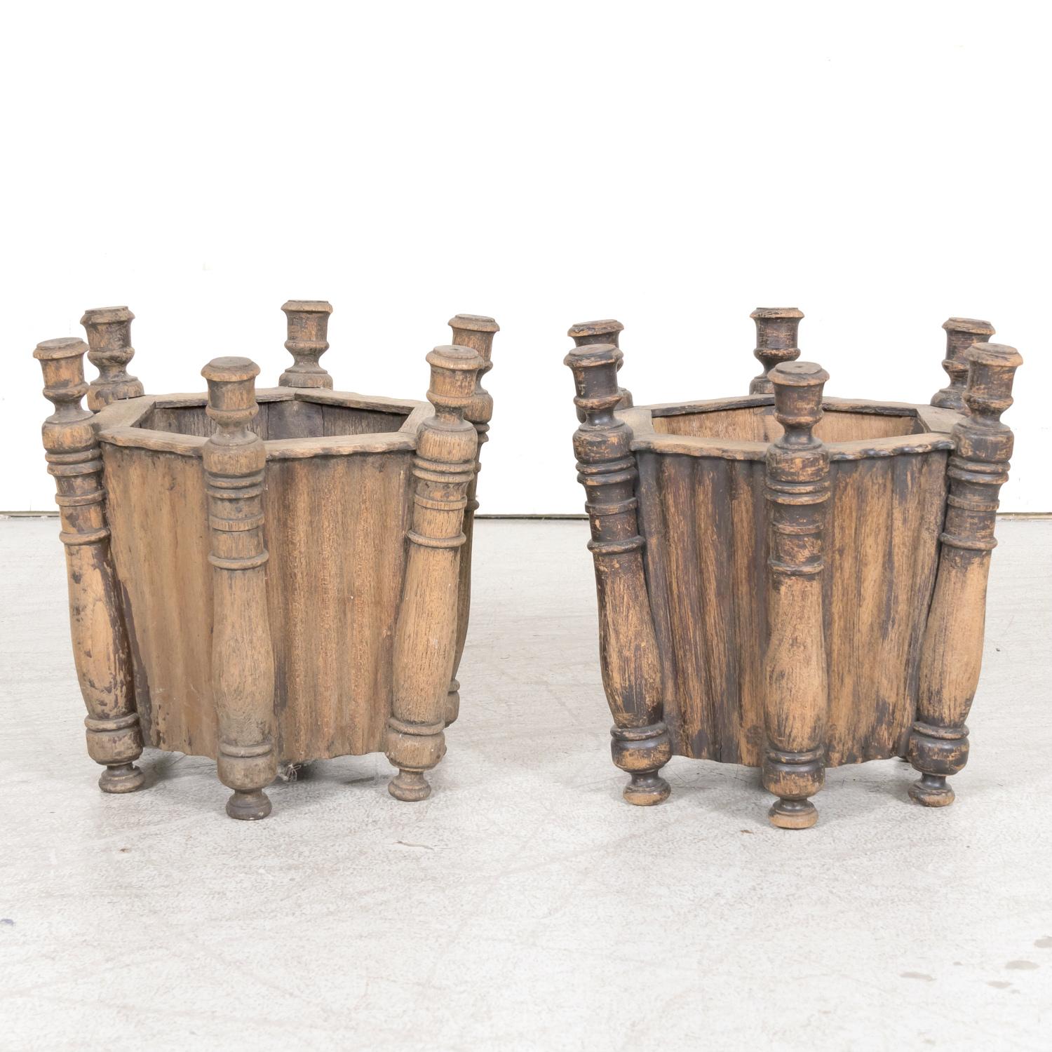 A handsome pair of antique French carved oak hexagonal planters or jardinieres, circa 1900s. Having a beautiful sun bleached patina from years in the scorching Mediterranean sun, they will add character and charm to any garden, patio, or indoor