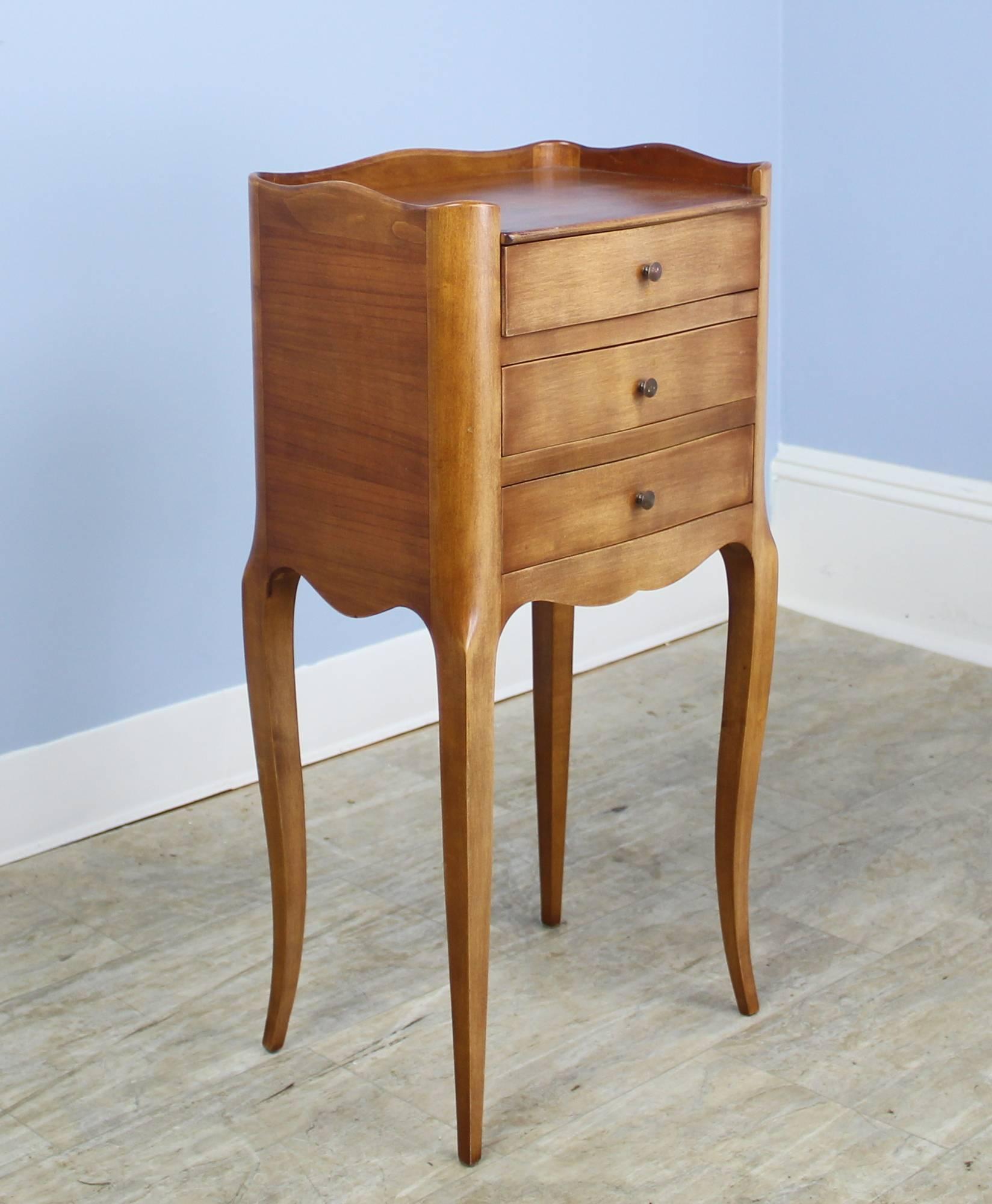 A pair of fine charming cherry nightstands with three sweet drawers and gracefully curved cabriole legs. The tops are in very good condition, with a small gallery on three of the four sides. Wonderful color and good cherry grain.