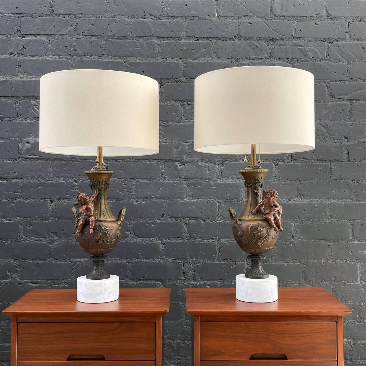 Pair of Antique French Classical Urn Style Table Lamps with Cherubs 

Country: France  
Materials: Painted Bronze, Carrara Marble
Condition: Newly Rewired, New Brass Sockets, New Custom Linen Shades
Style: French Louis XVI
Year: 1920’s

$4,500 set