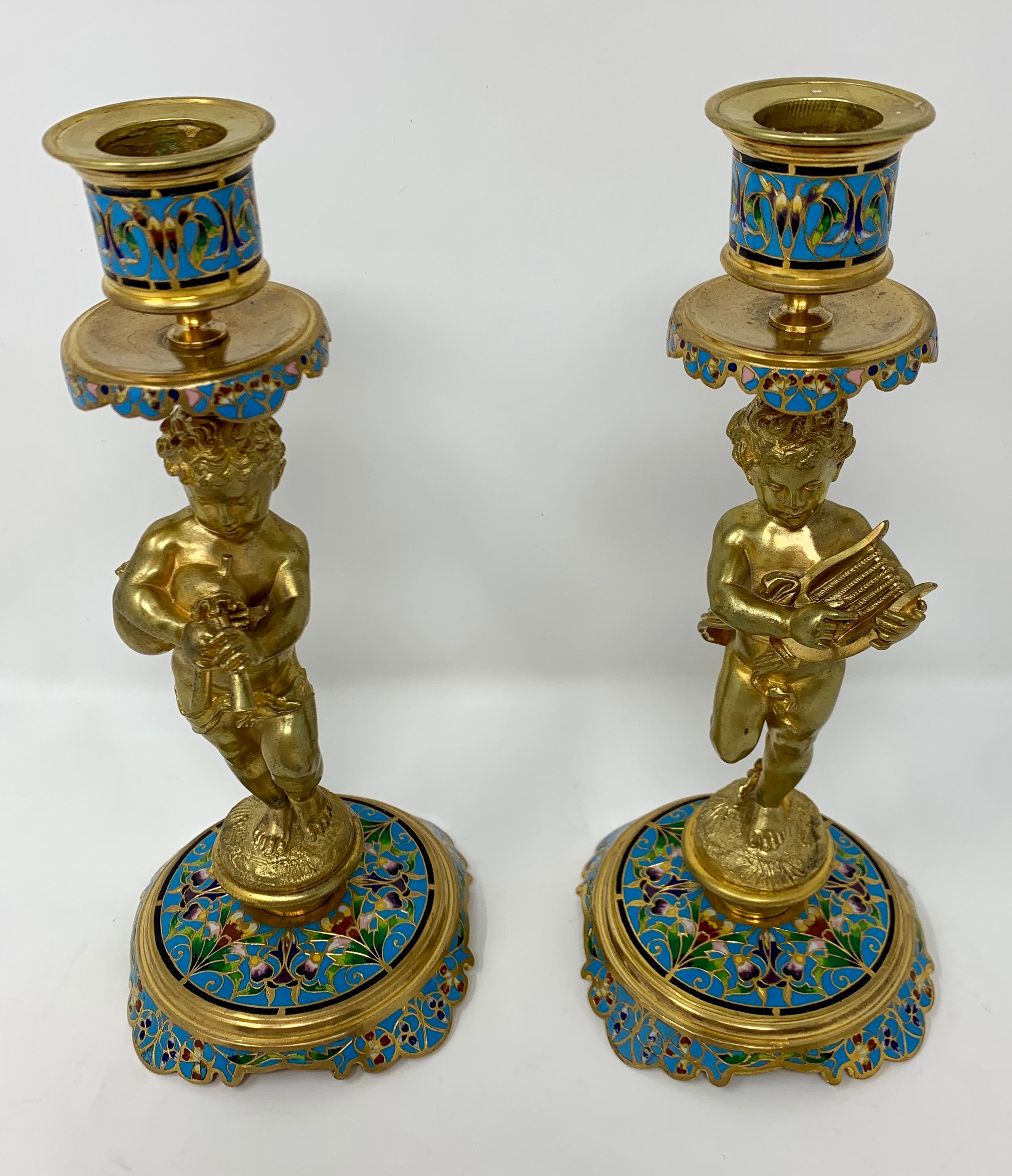 A charming pair of candlesticks whose cherubs are sporting musical instruments.
